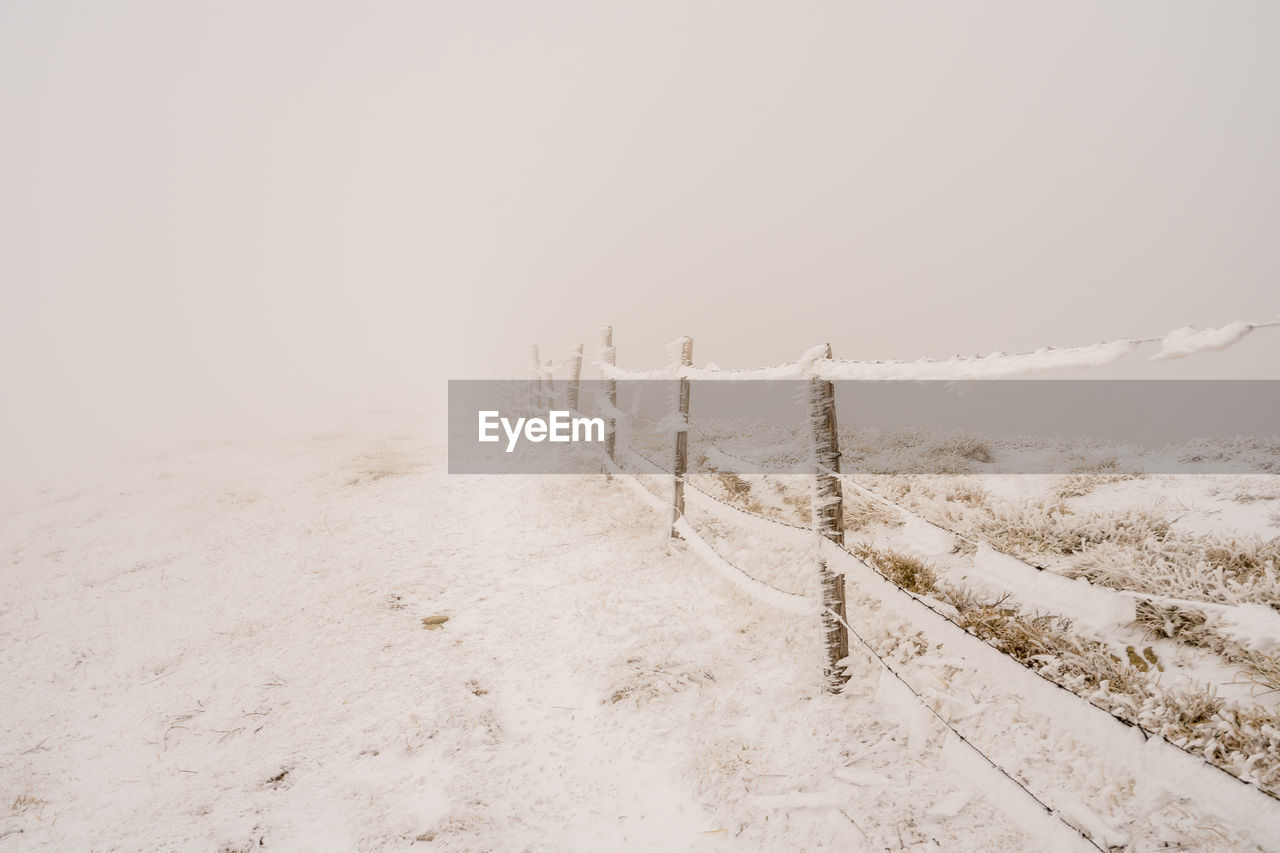 Scenic view of snow covered field against sky