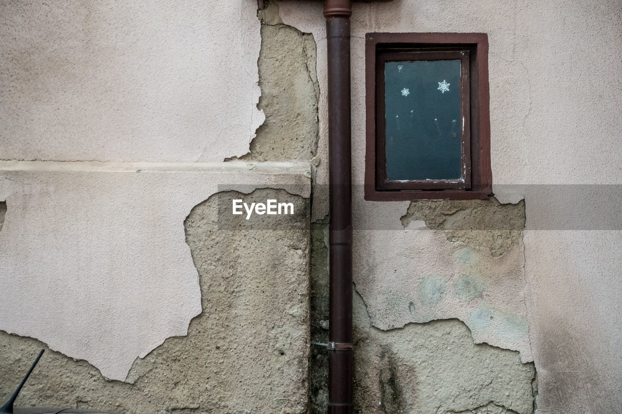 LOW ANGLE VIEW OF WINDOW ON OLD HOUSE