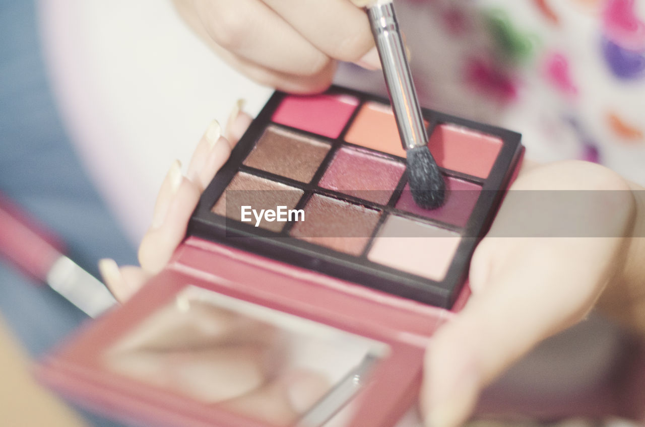 Close-up of woman holding eyeshadow palette