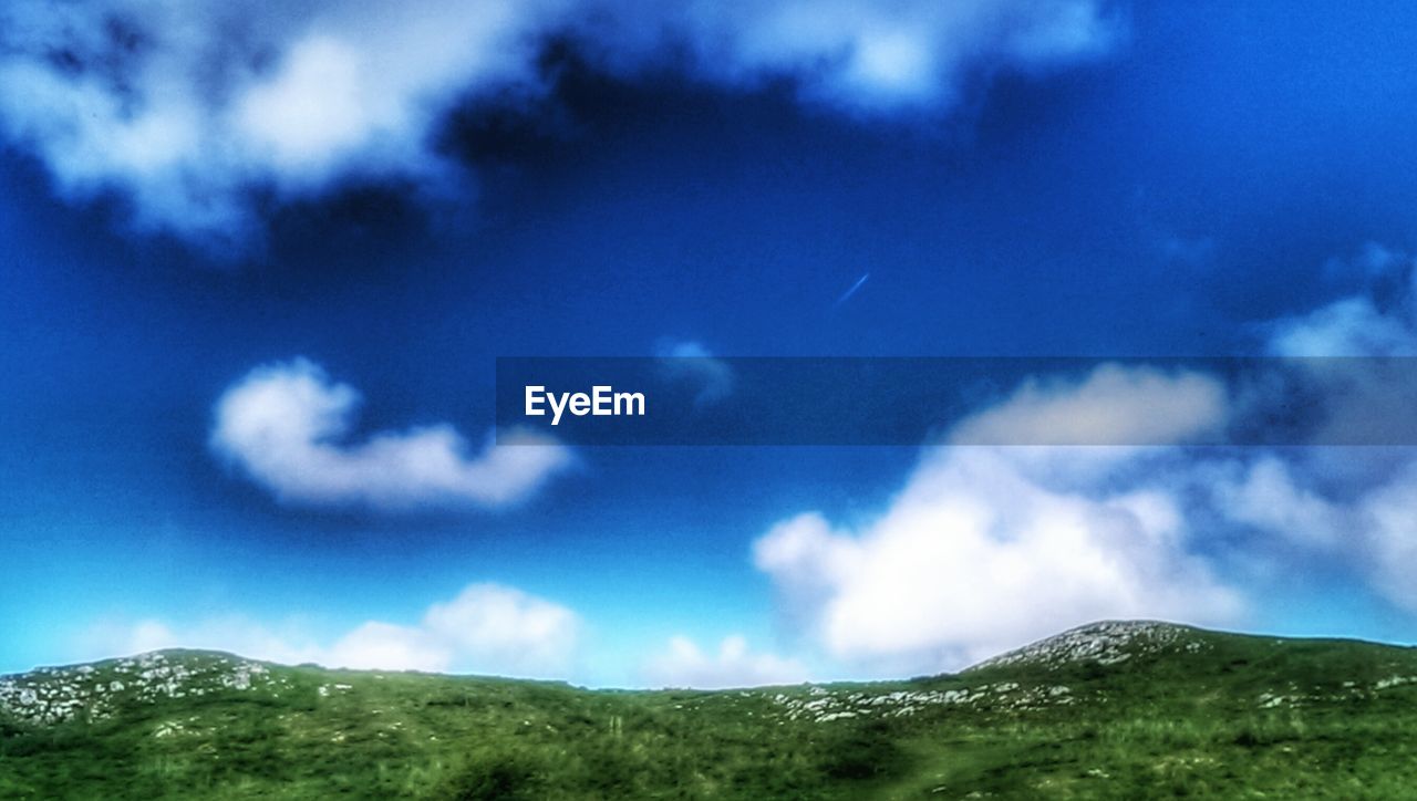 SCENIC VIEW OF MOUNTAINS AGAINST CLOUDY SKY