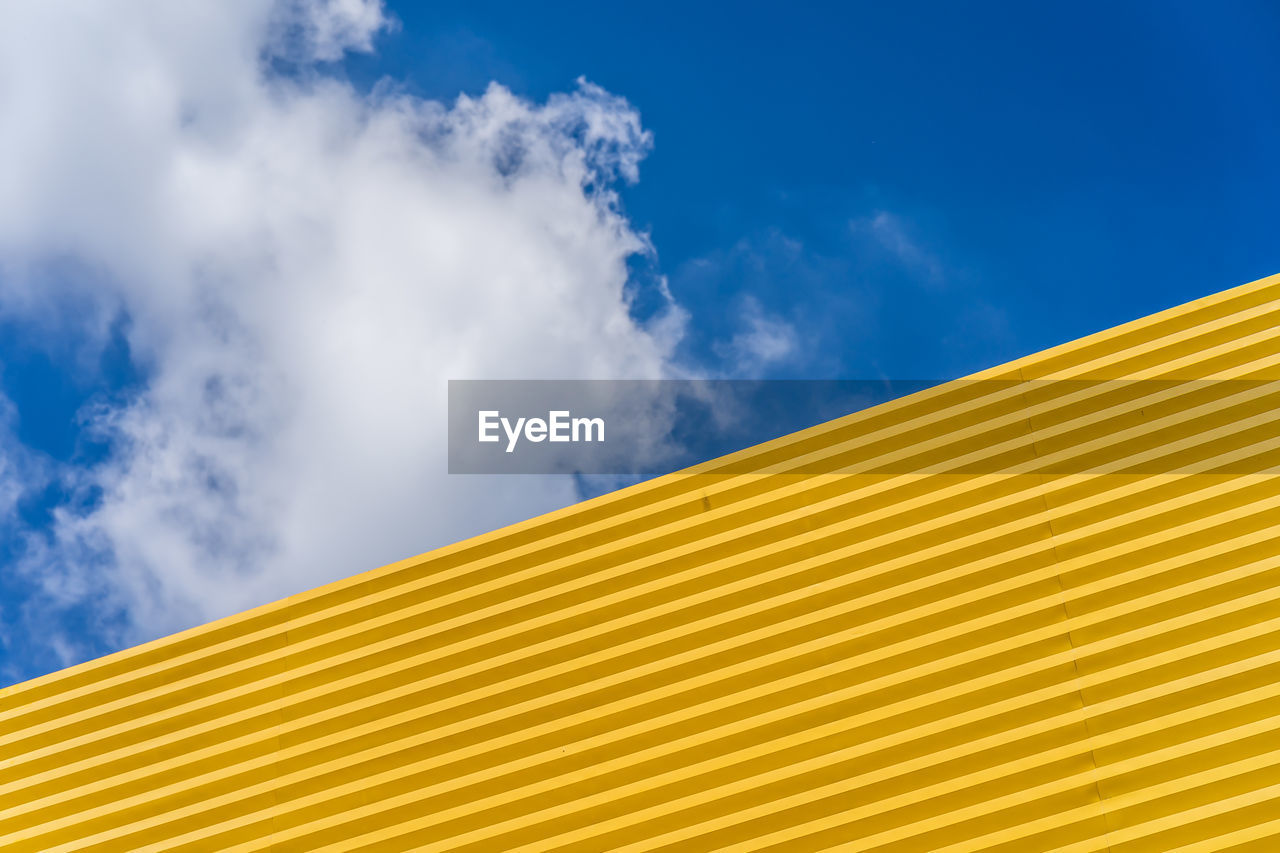 Low angle view of yellow building against sky