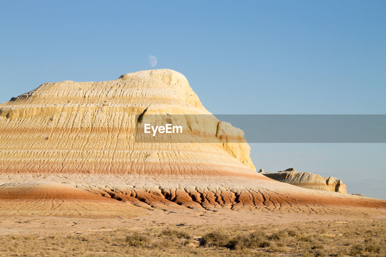 landscape, land, sky, scenics - nature, sand, environment, nature, desert, travel destinations, natural environment, clear sky, beauty in nature, travel, non-urban scene, no people, rock, monument, blue, climate, day, tranquility, rock formation, geology, sunny, tranquil scene, wadi, plateau, outdoors, sand dune, tourism, remote, arid climate, dry, sunlight, extreme terrain, formation, physical geography, semi-arid, mountain