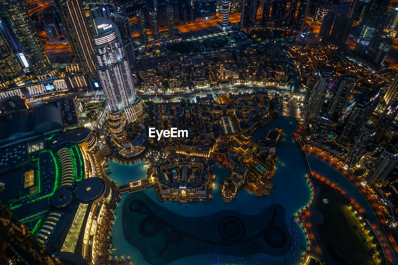 HIGH ANGLE VIEW OF ILLUMINATED CITY BUILDINGS AT NIGHT