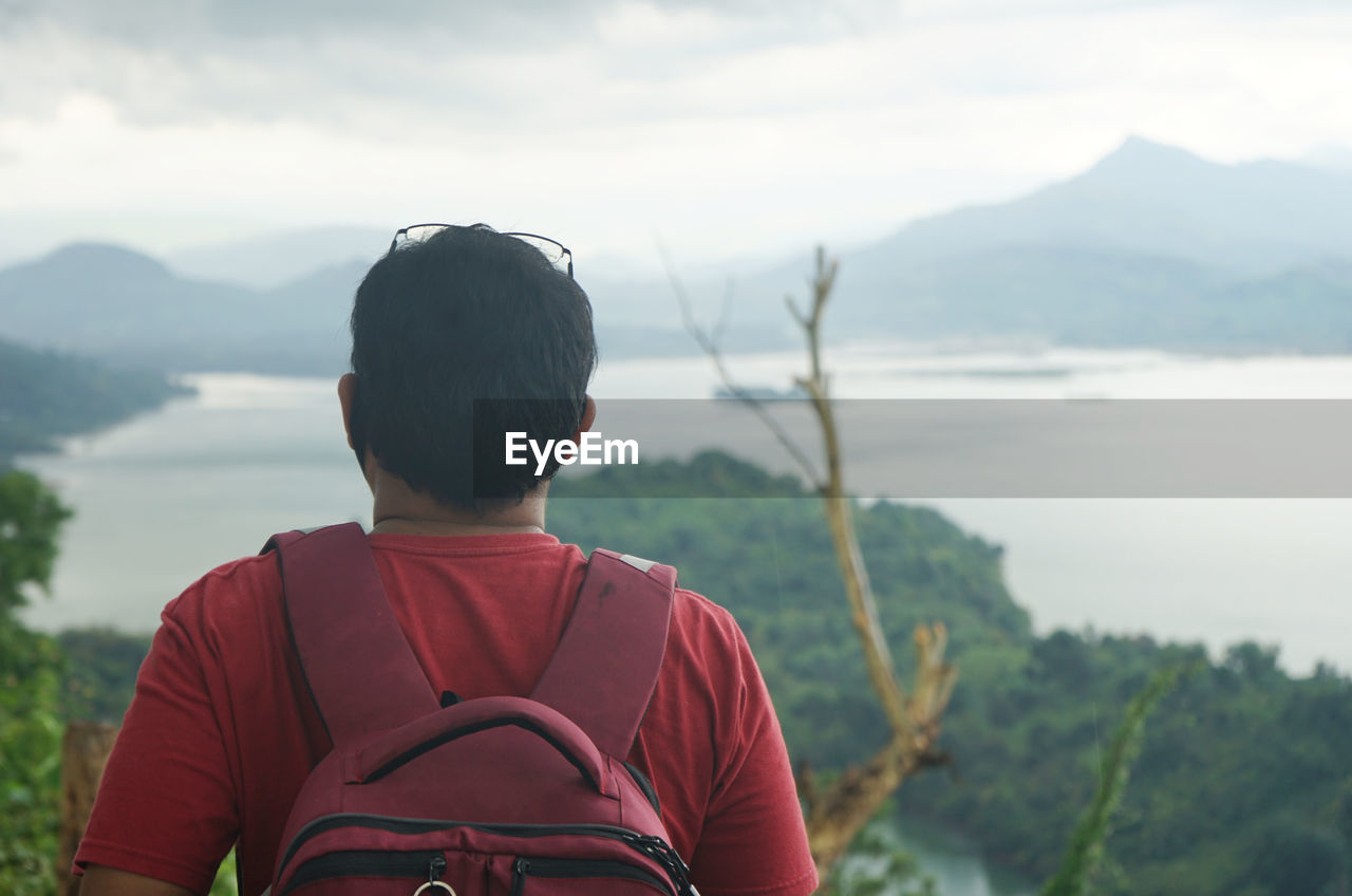 REAR VIEW OF MAN LOOKING AT MOUNTAIN