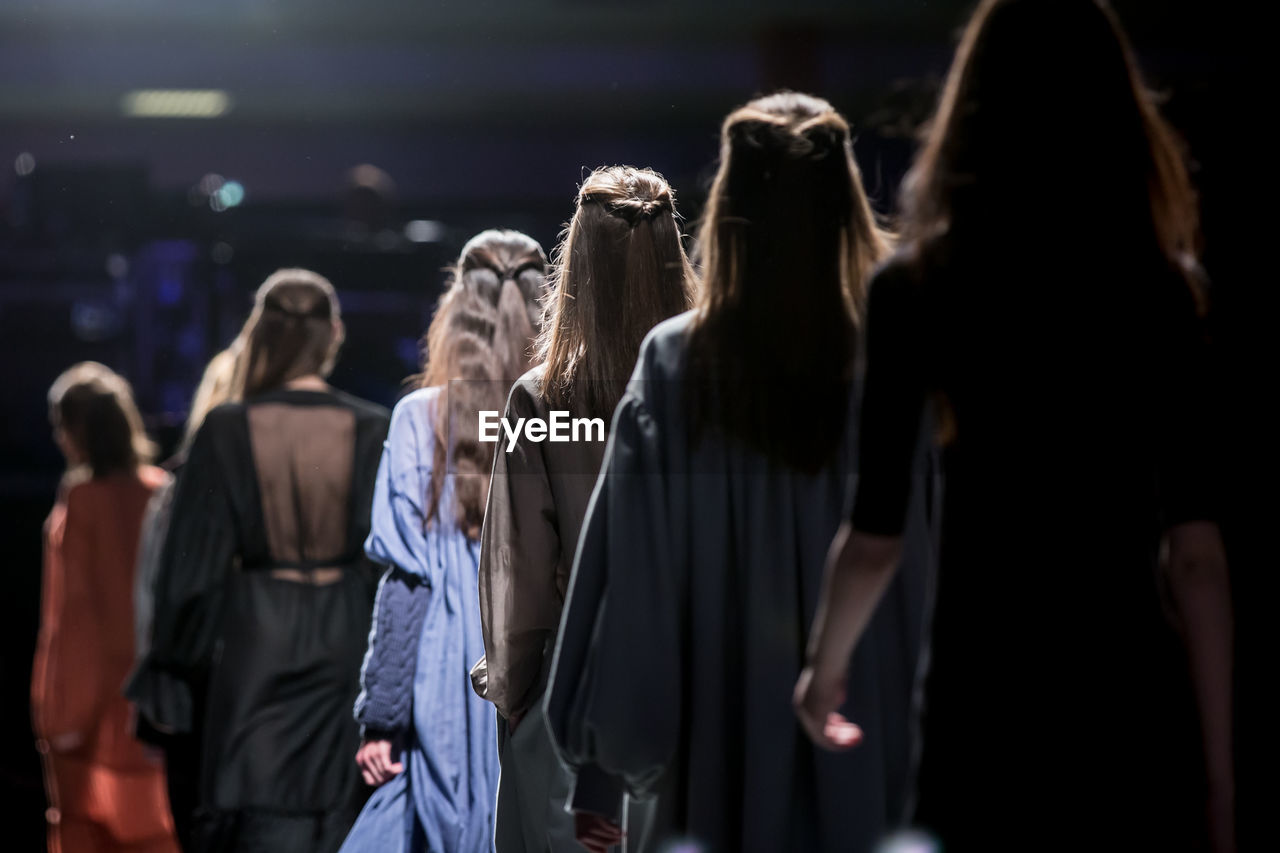 Rear view of models in row during fashion show
