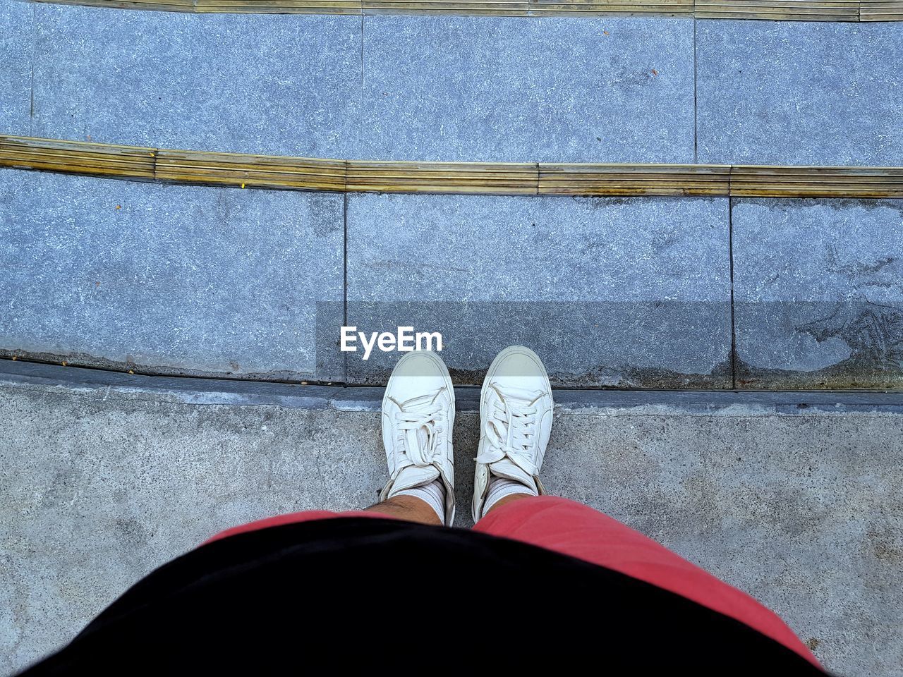 Low section of man standing on footpath