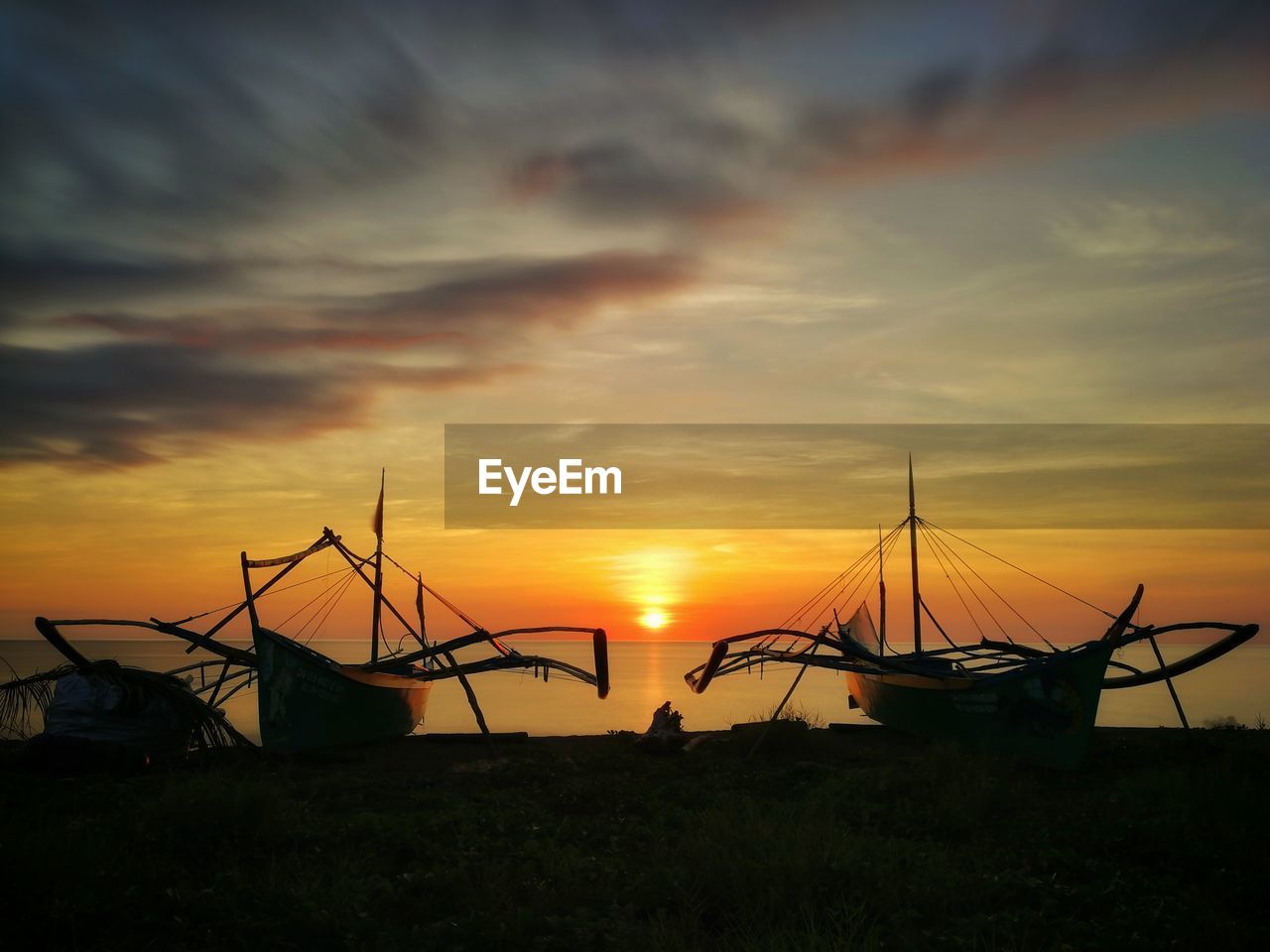 SILHOUETTE SAILBOATS ON LAND AGAINST SKY DURING SUNSET