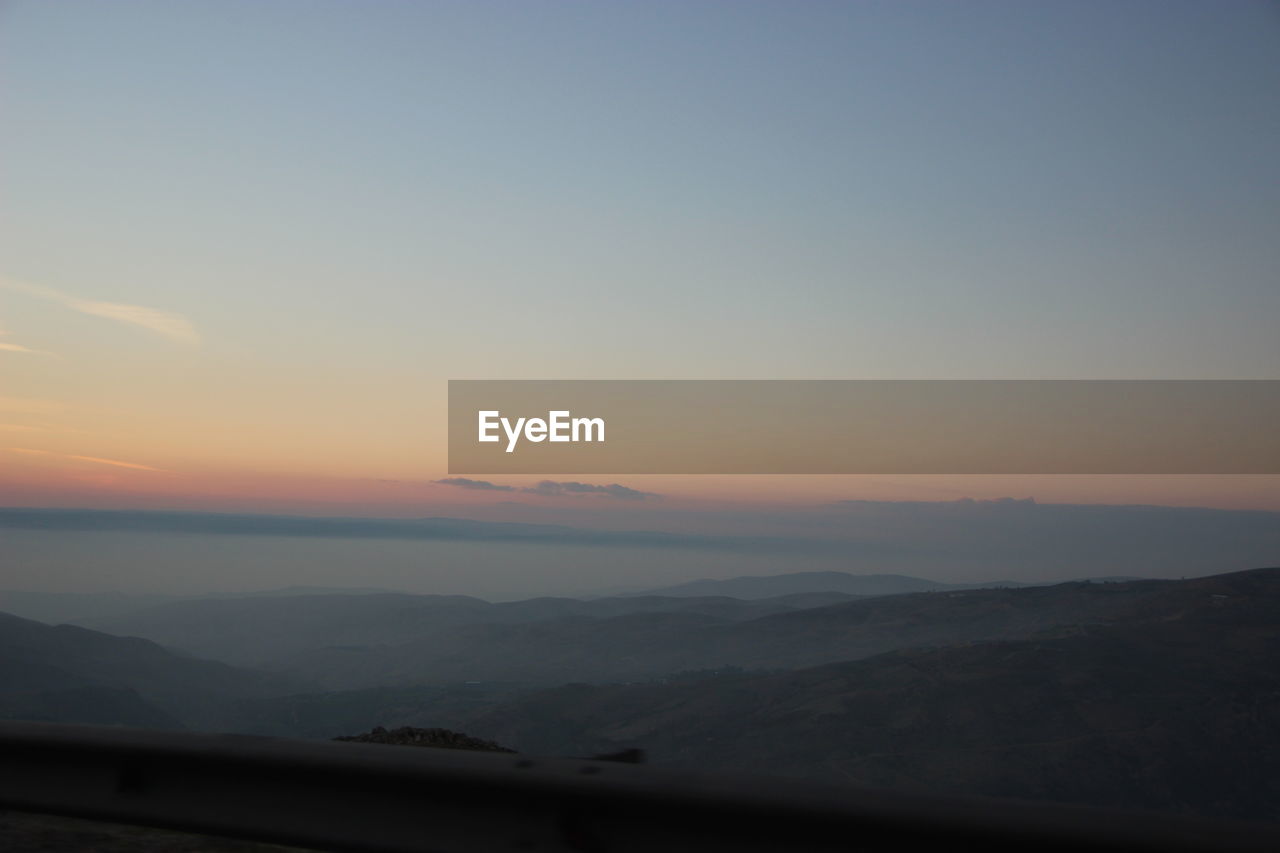 SCENIC VIEW OF SILHOUETTE MOUNTAINS AGAINST SKY AT SUNSET