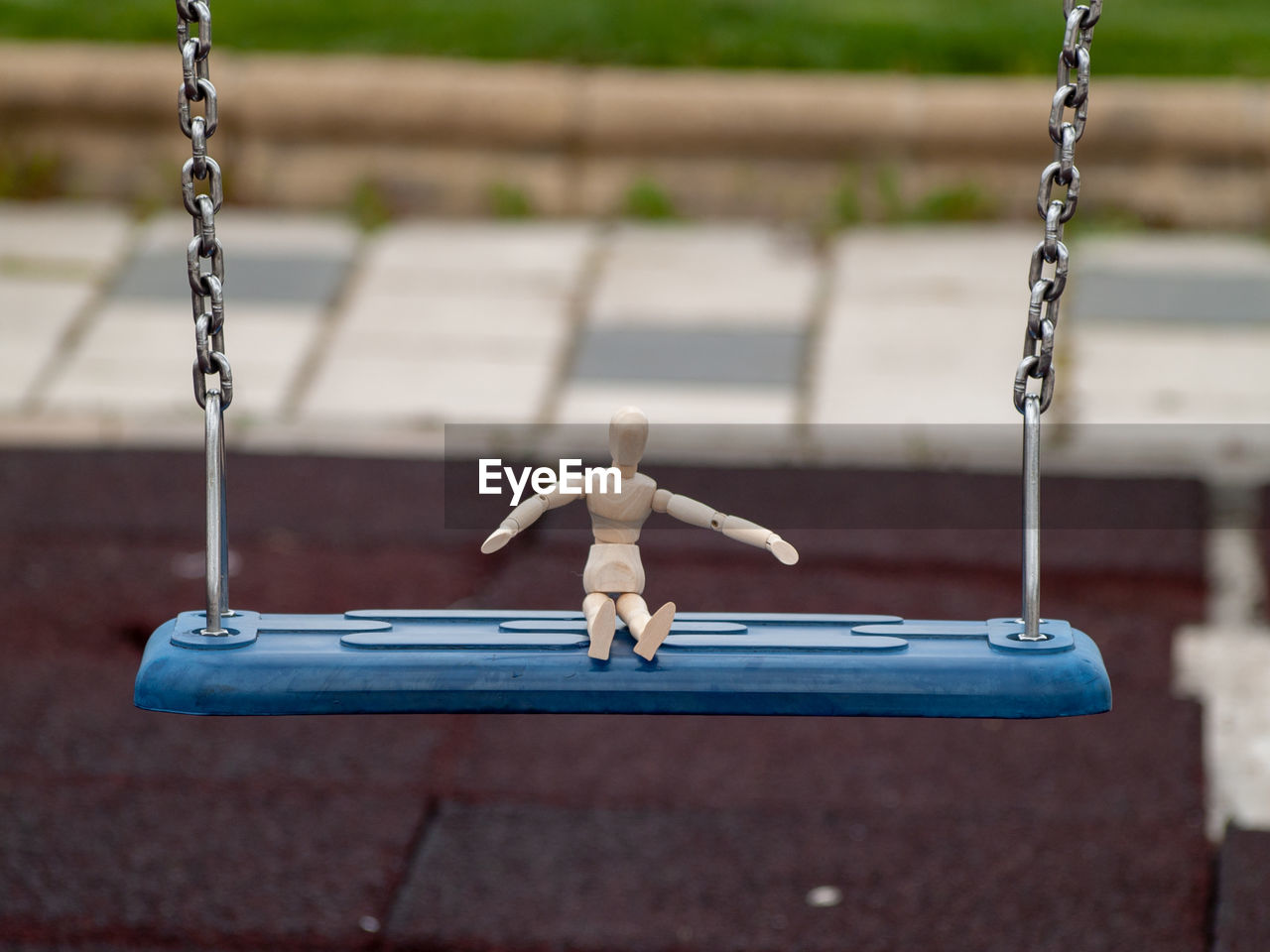 Figurine on swing at playground