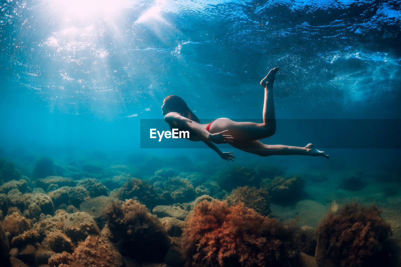 side view of man swimming in sea