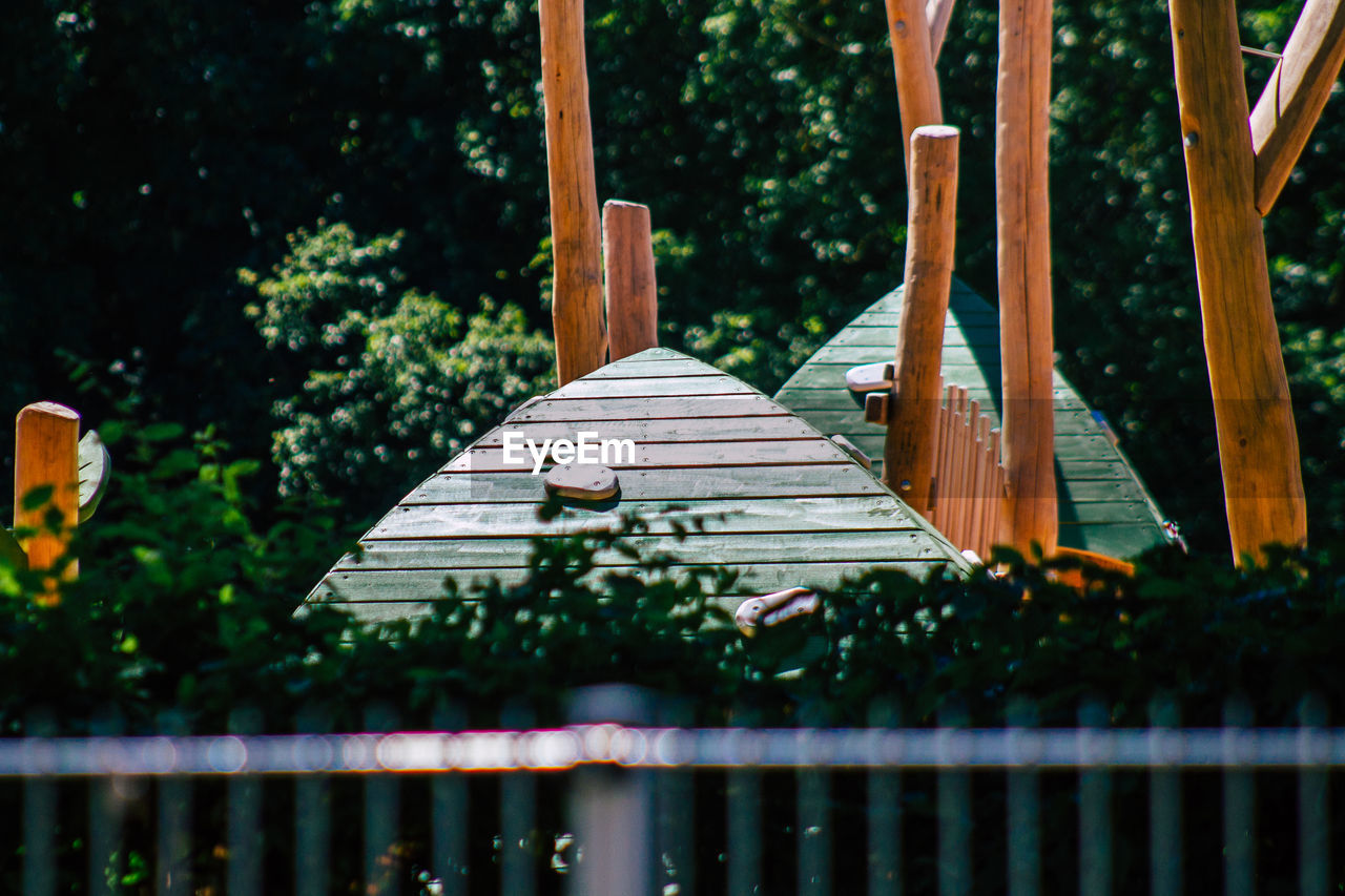 WOODEN RAILING BY TREES