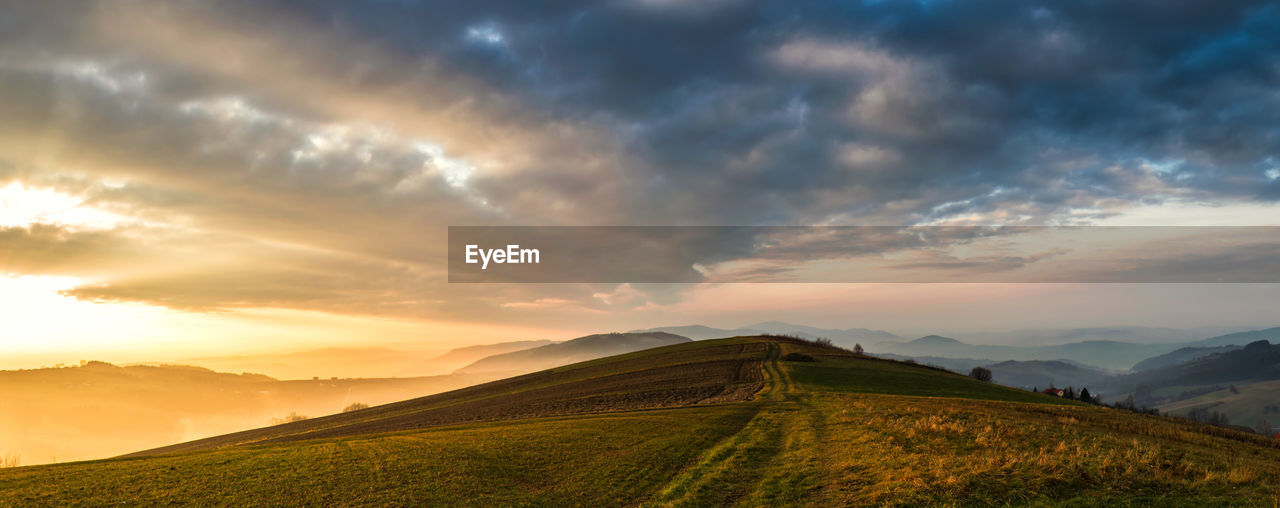 Scenic view of field against sky during sunset