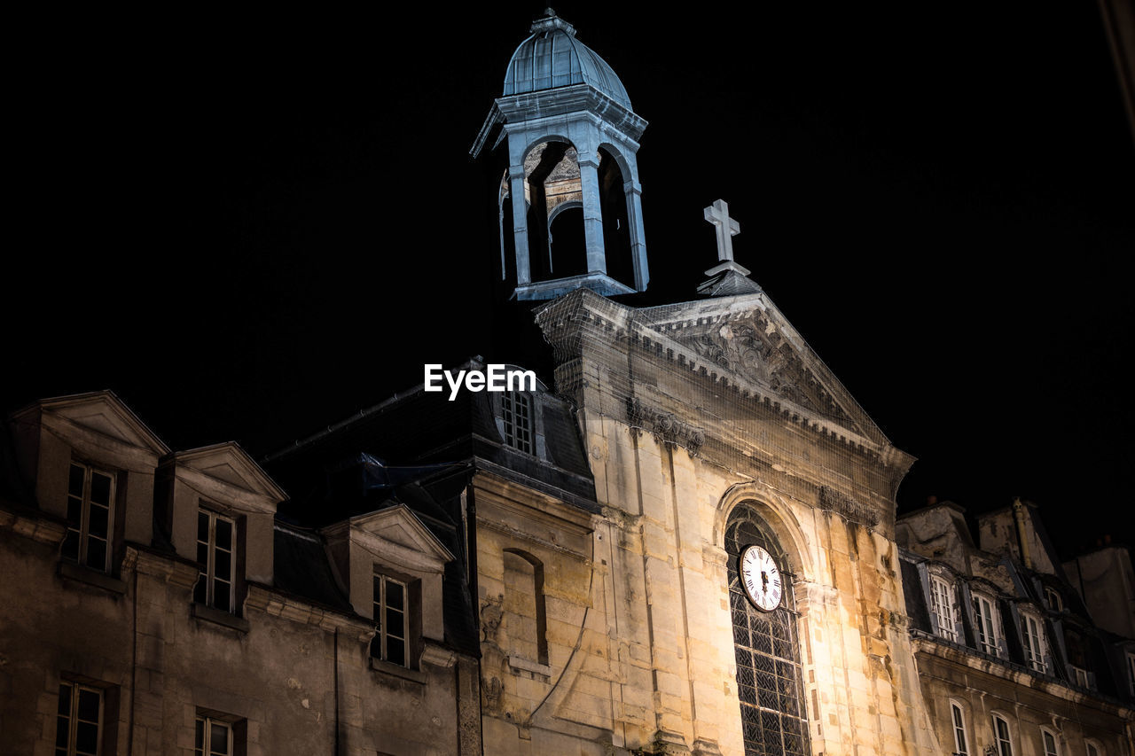 LOW ANGLE VIEW OF STATUE AGAINST ILLUMINATED CATHEDRAL