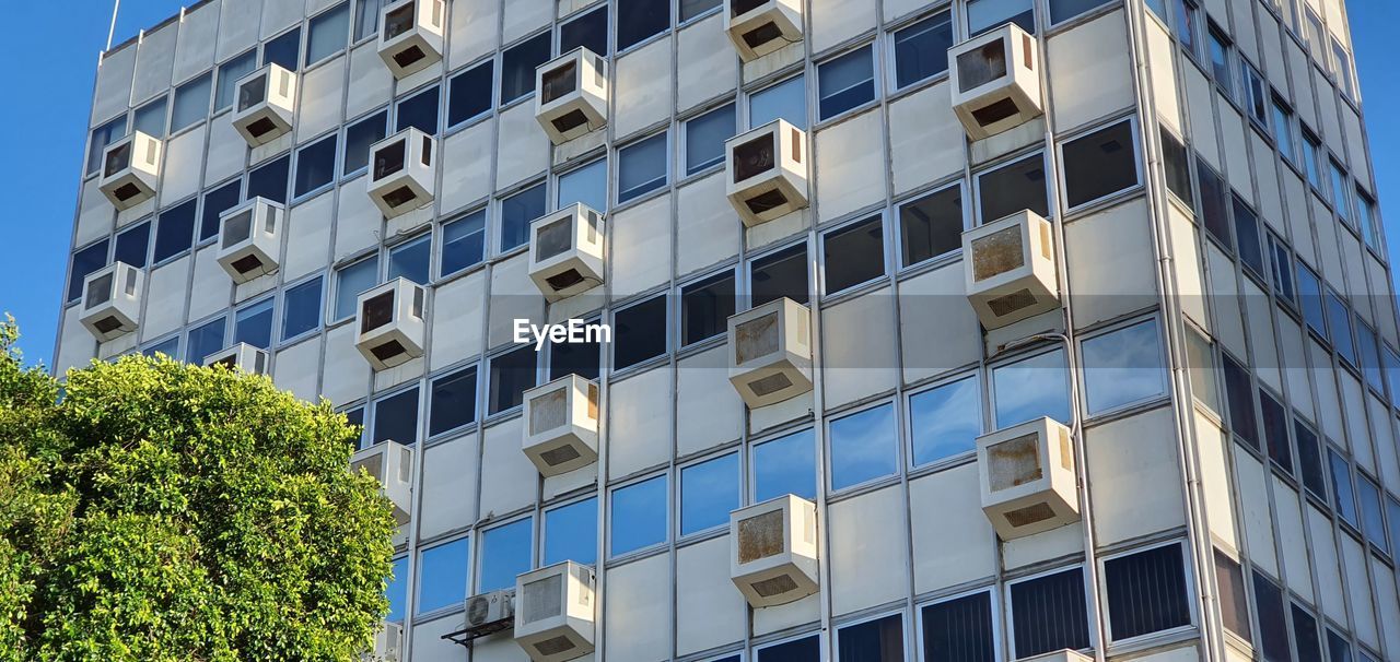 Low angle view of modern building against blue sky