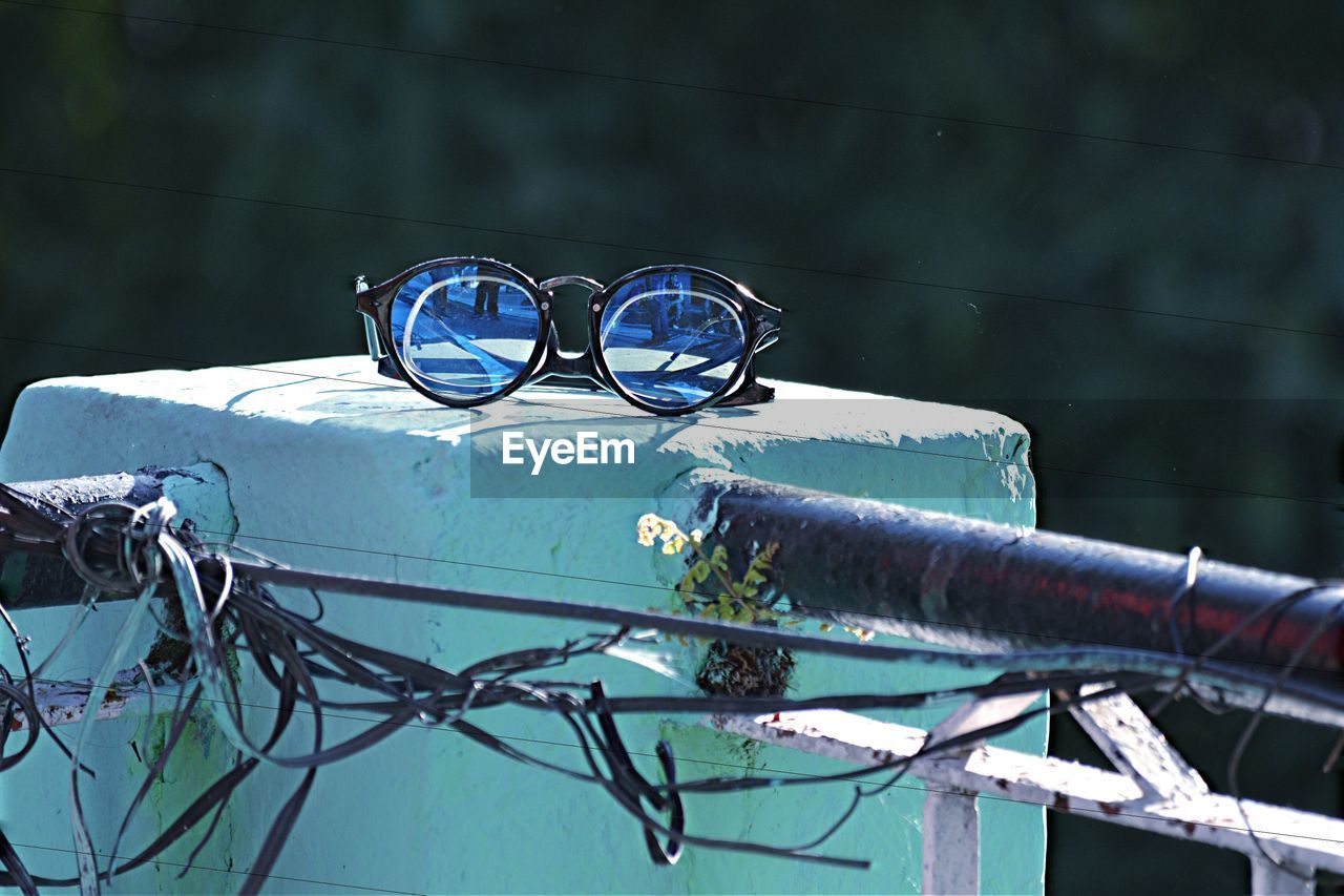 Close-up of sunglasses on railing