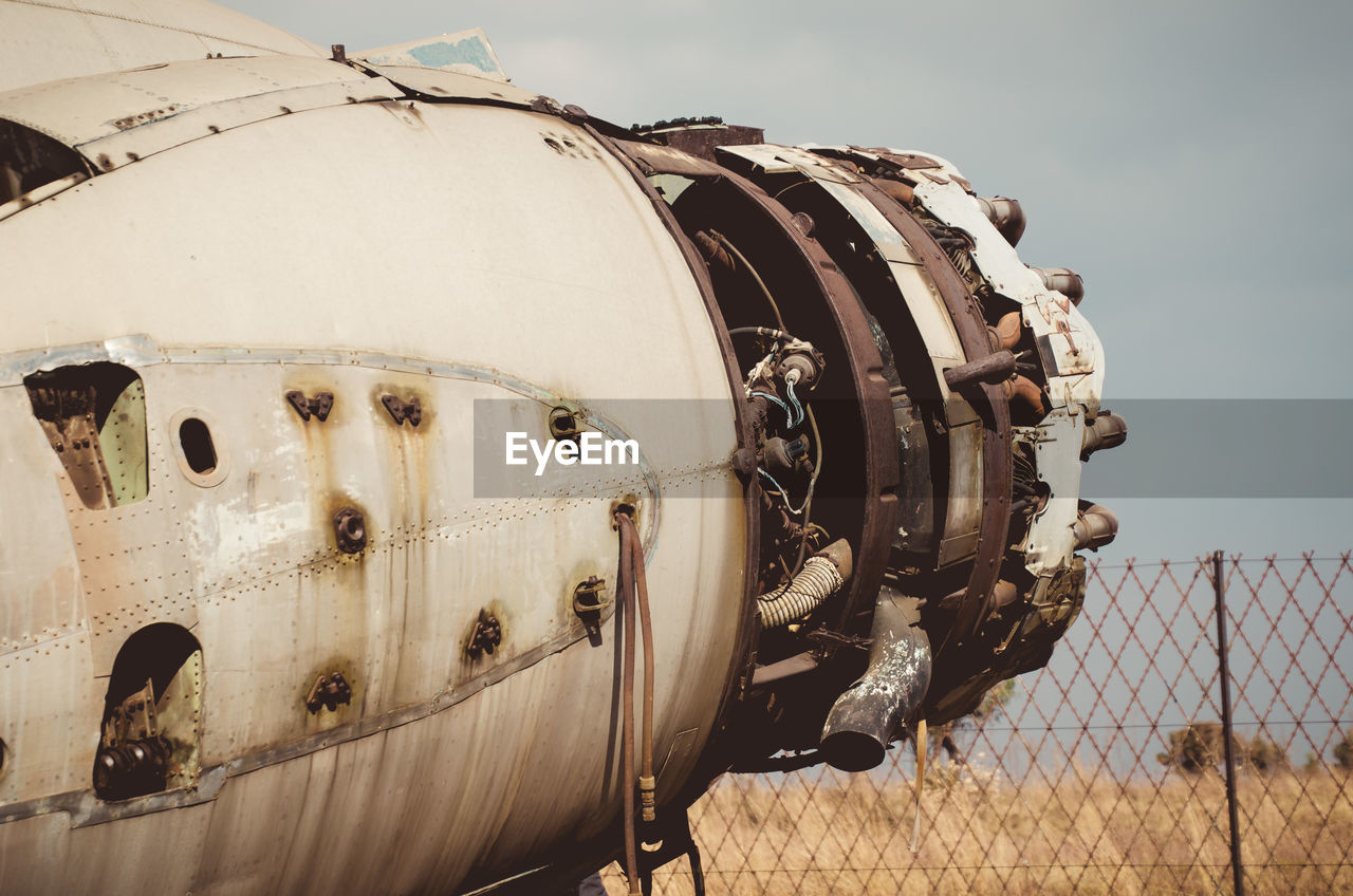 CLOSE-UP OF ABANDONED AIRPLANE ON FIELD