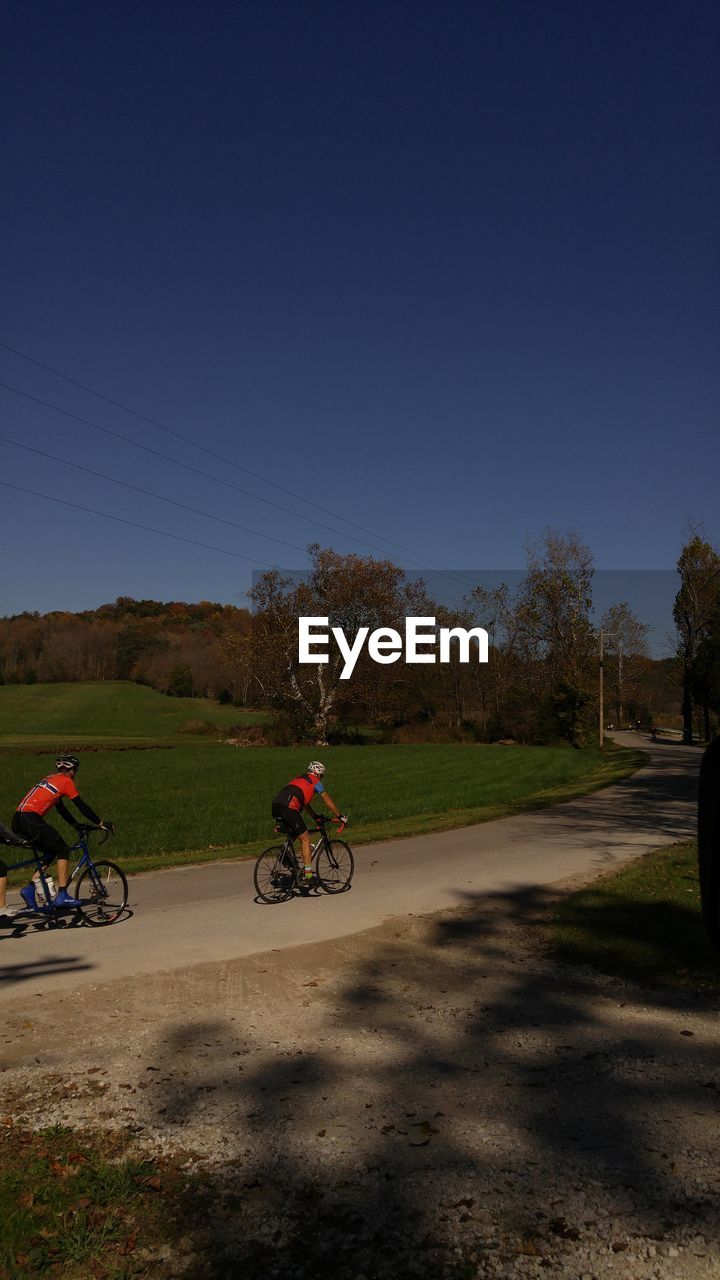 BICYCLE ON DIRT ROAD AGAINST CLEAR BLUE SKY