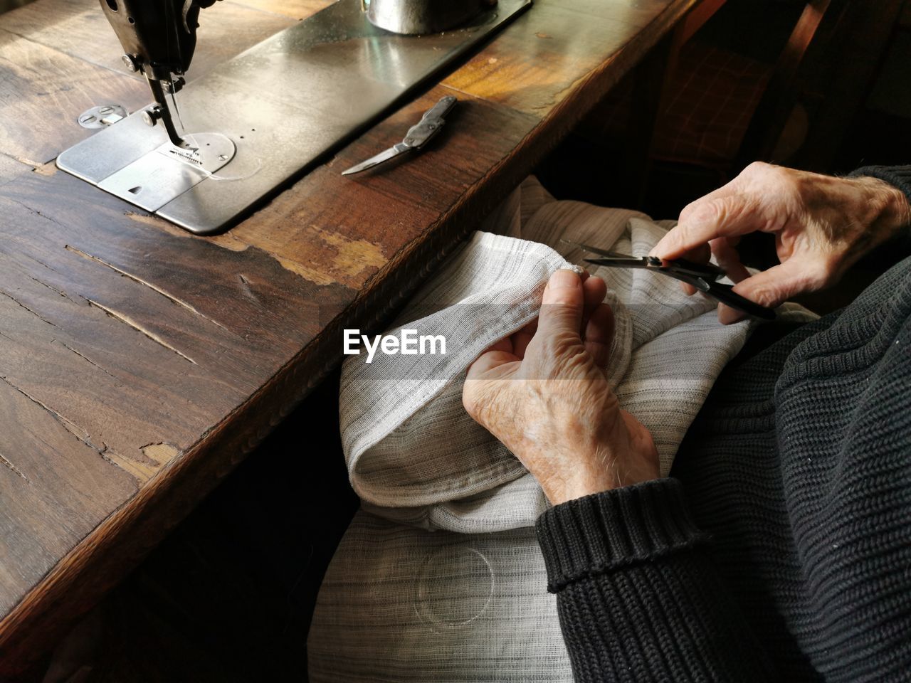 High angle view of man hands. old man, tailor, sewing, fabric.