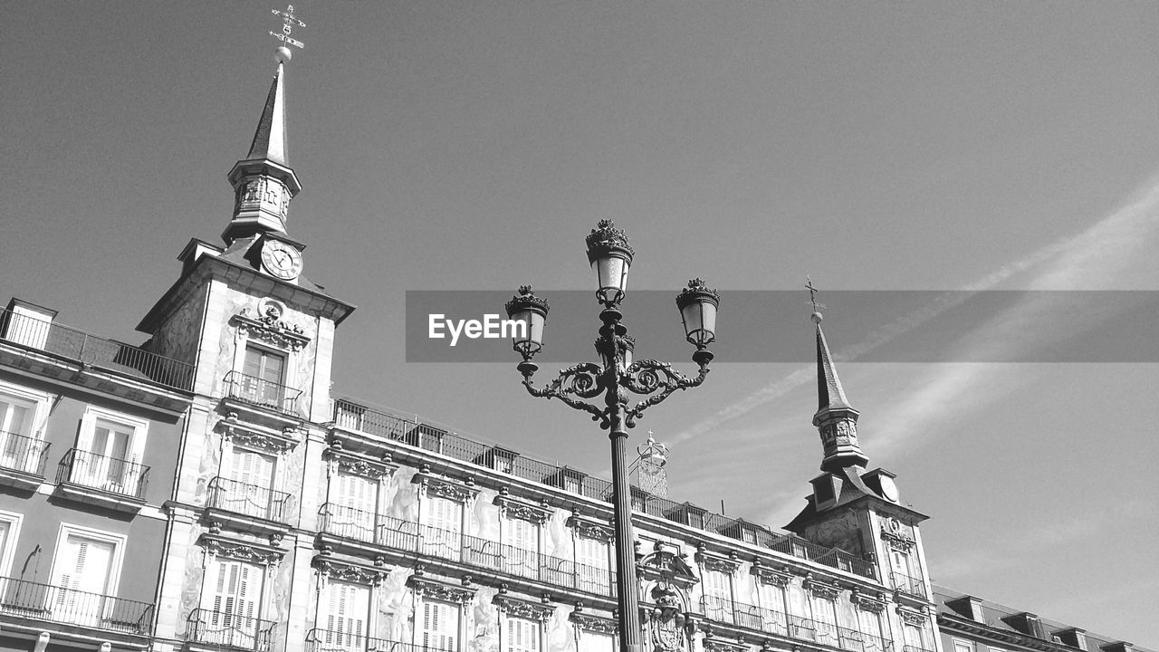 Low angle view of street light by church against sky