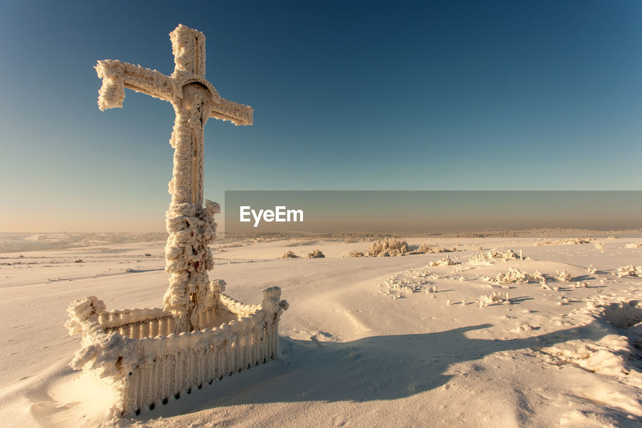 CROSS ON SNOW COVERED LAND