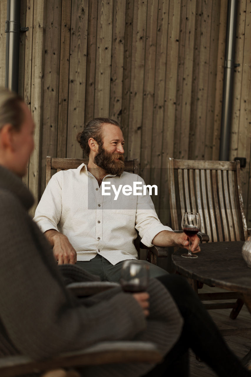 Friends sitting on porch and drinking wine
