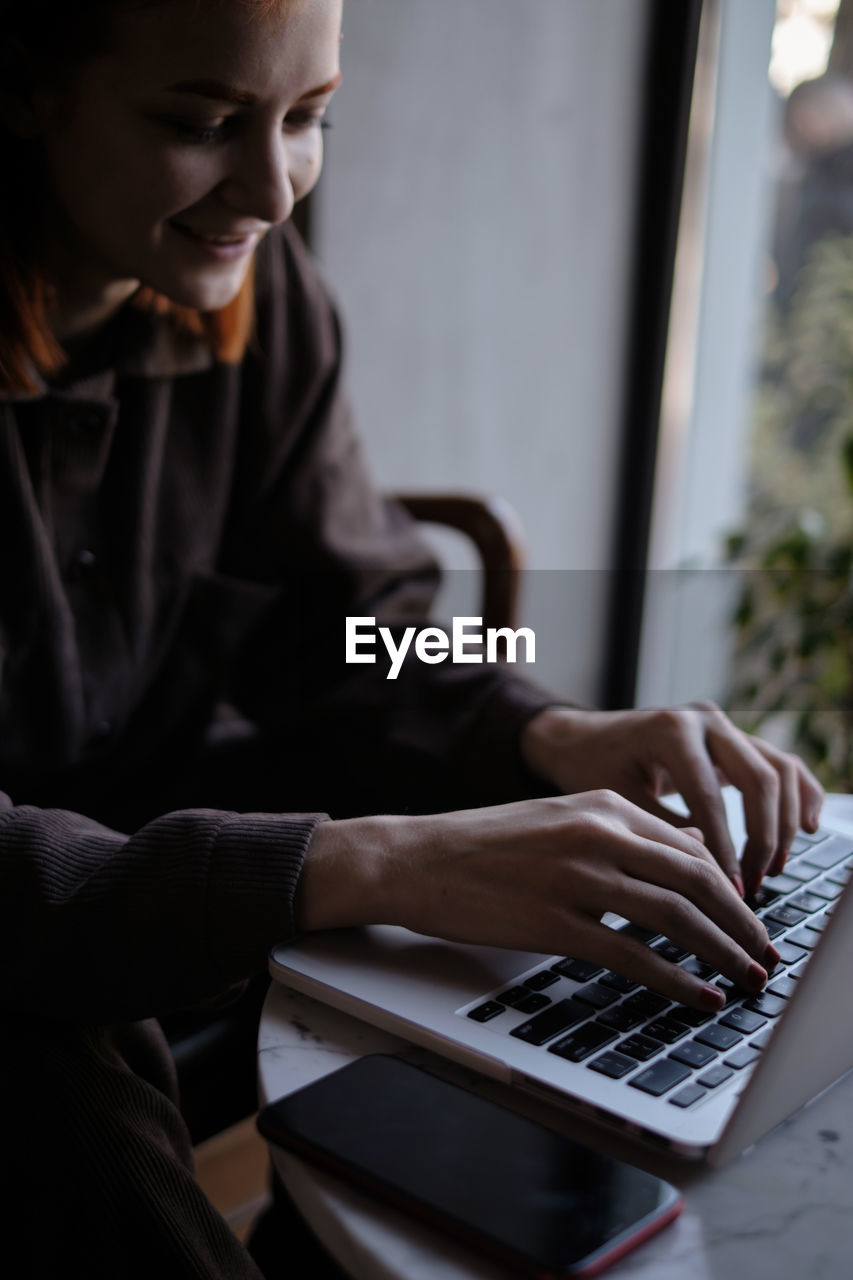 Smiling woman using laptop