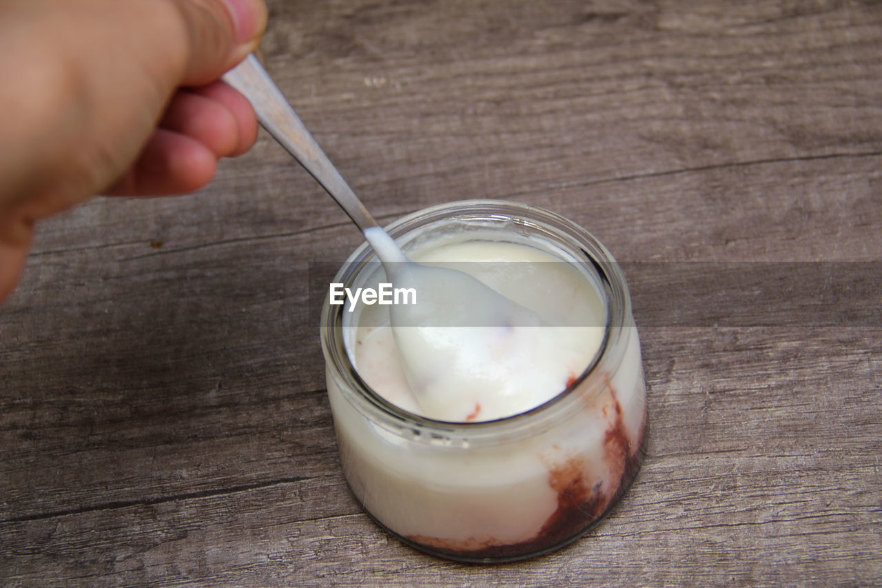 CLOSE-UP OF HAND HOLDING ICE CREAM