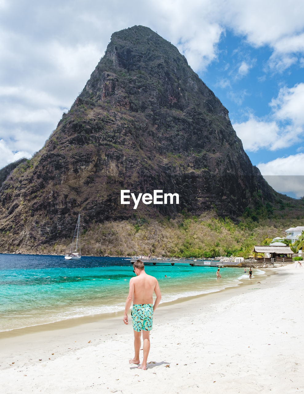 rear view of woman walking at beach against sky