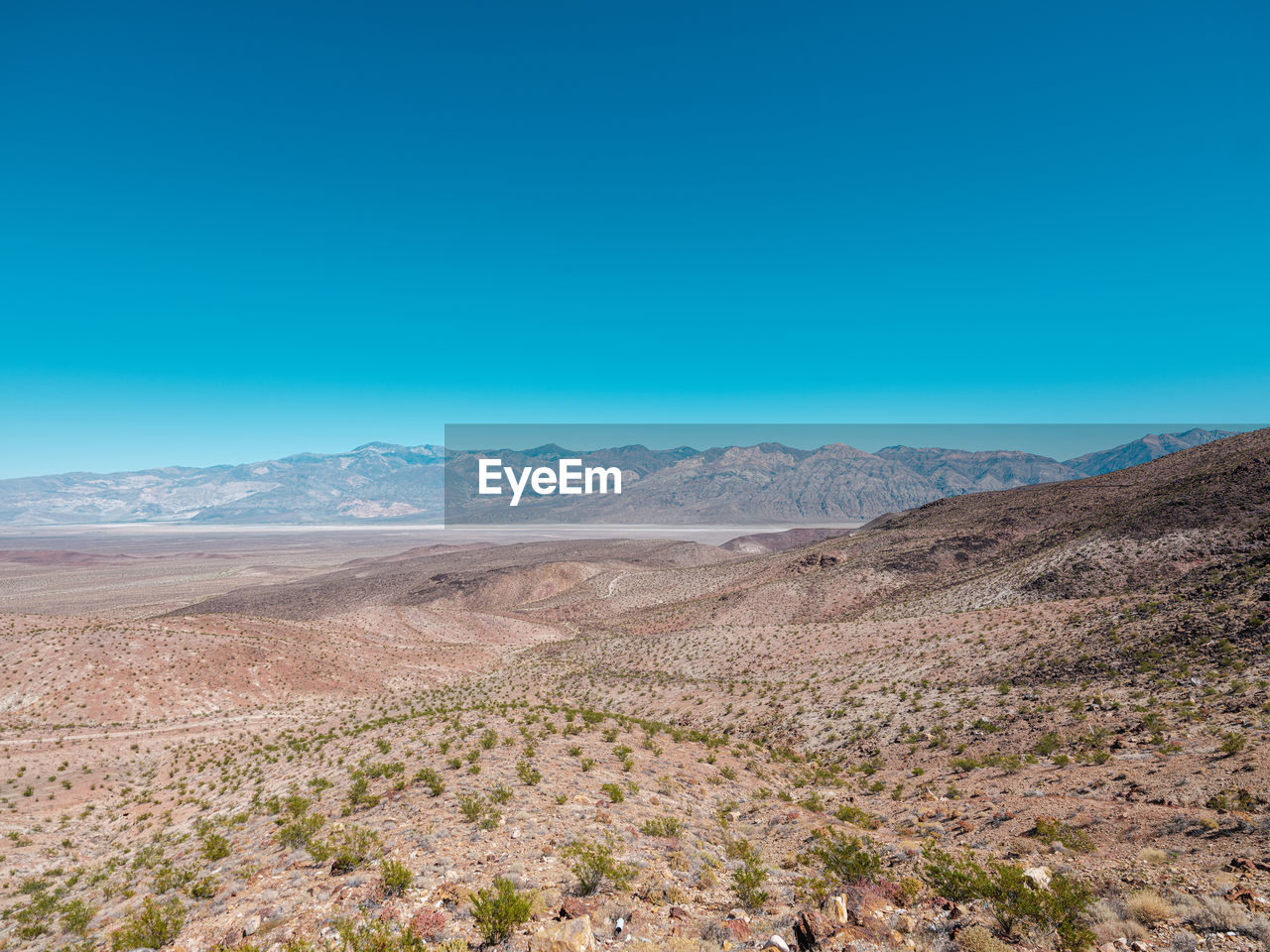 Scenic view of desert against clear blue sky
