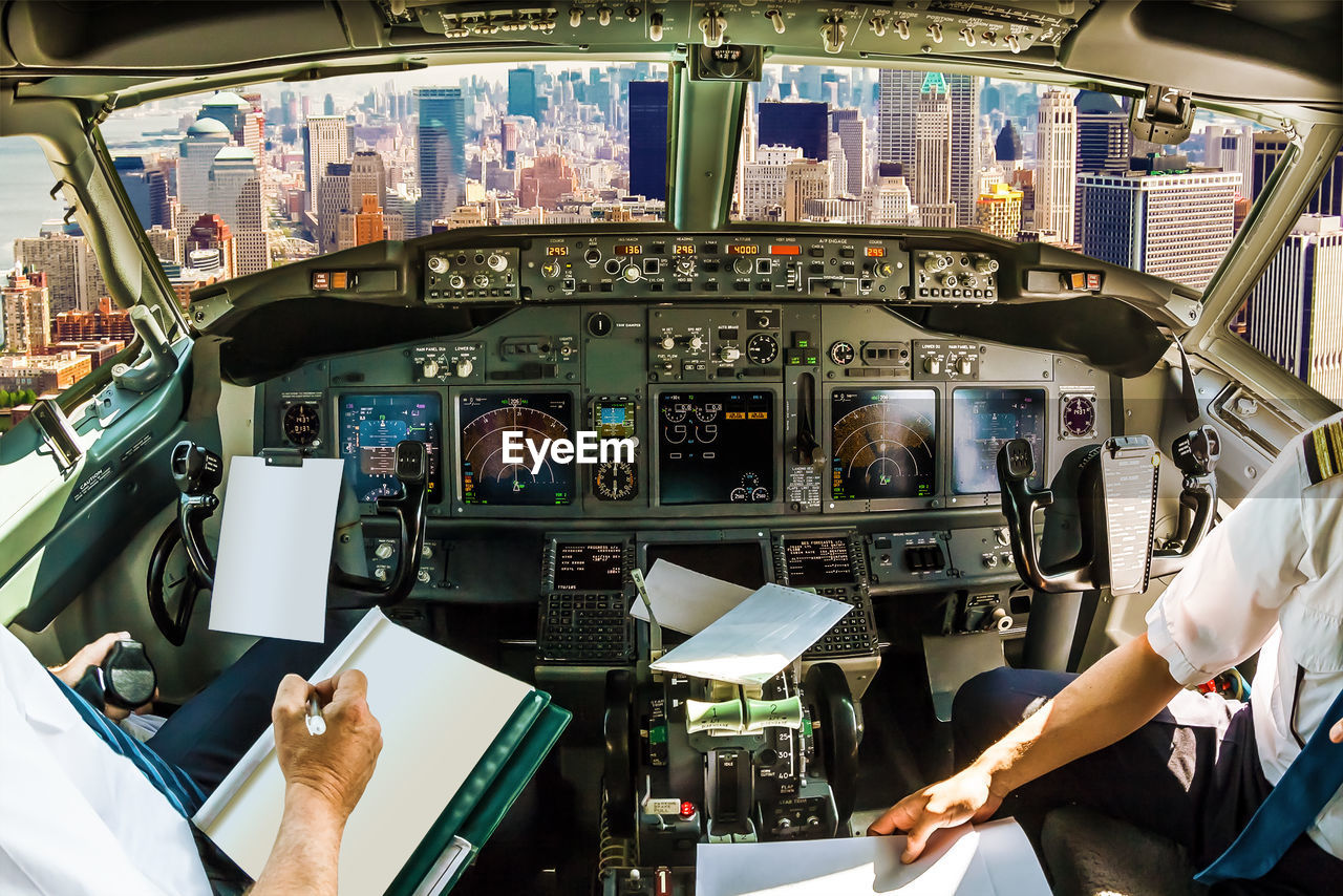 Pilots sitting in cockpit over city