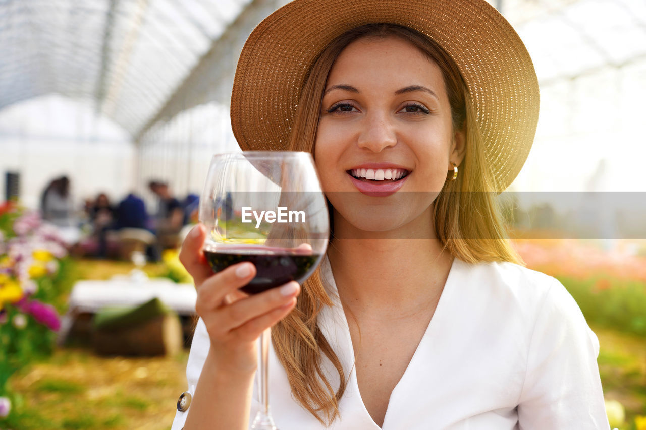 Photo of happy cheerful woman holds wine glass makes toast lookng at camera 