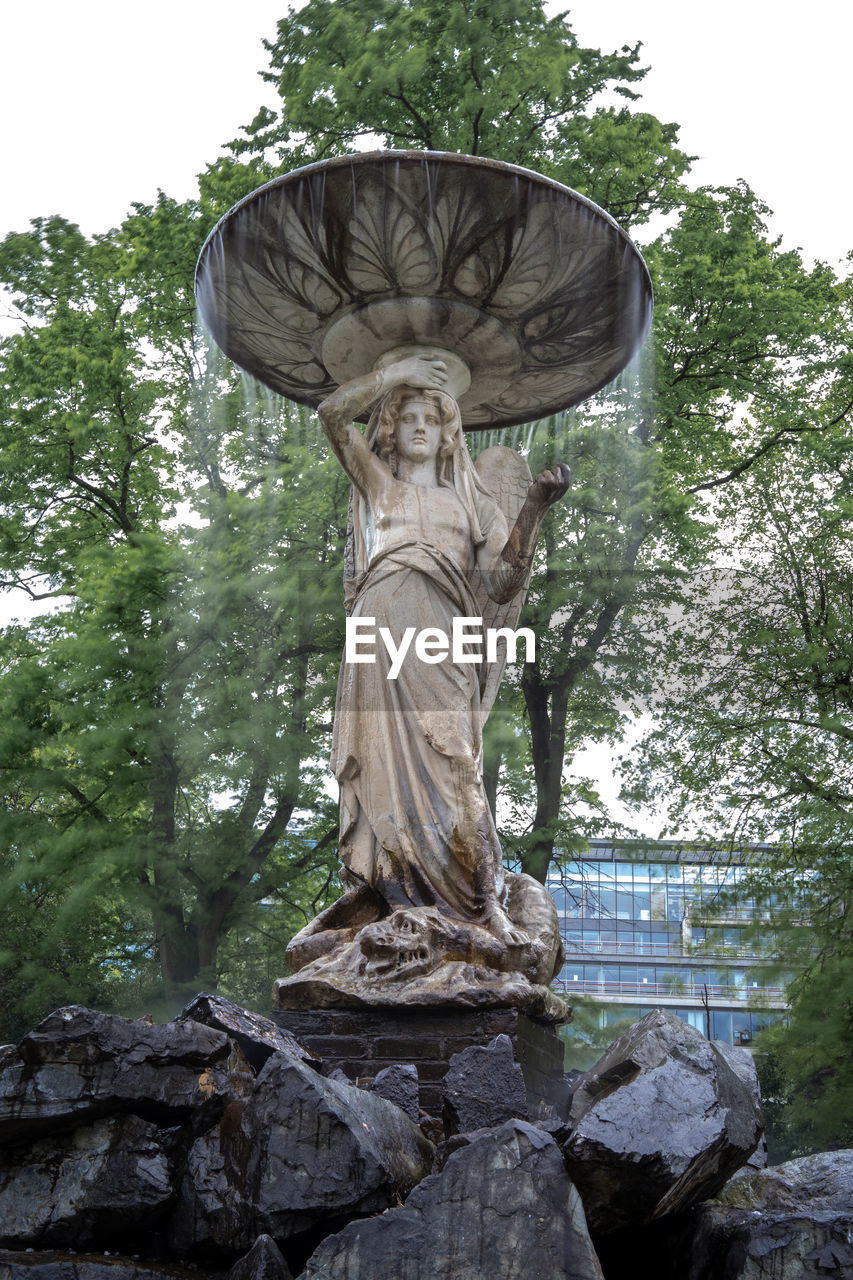 Low angle view of statue against trees in park