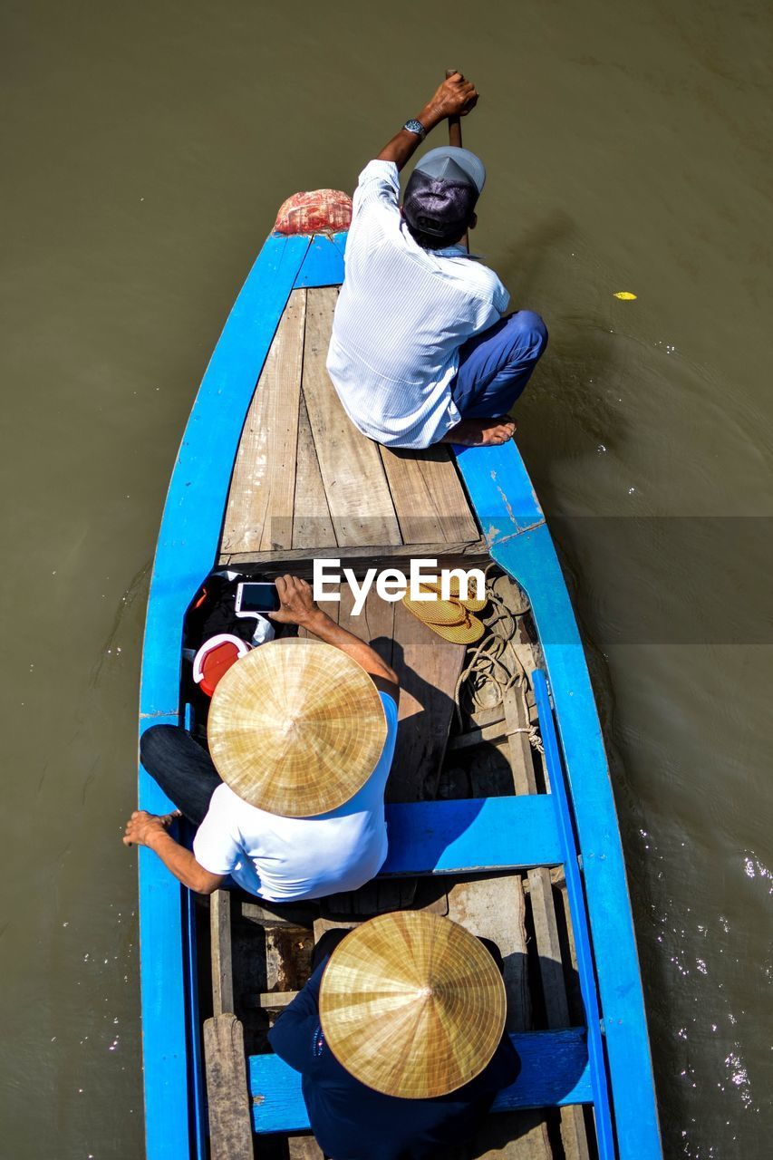 High angle view of men sitting in boat over lake