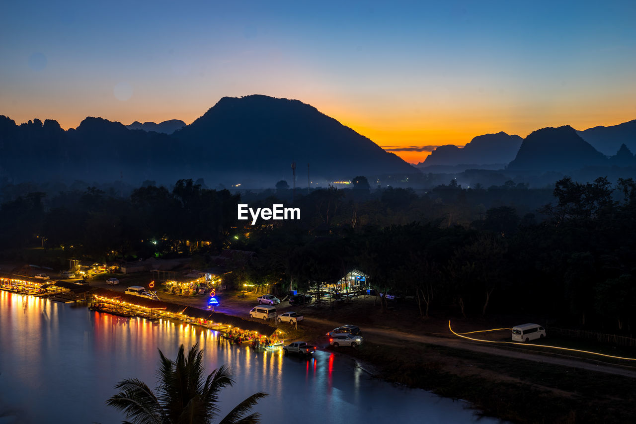 Scenic view of illuminated mountains against sky at sunset