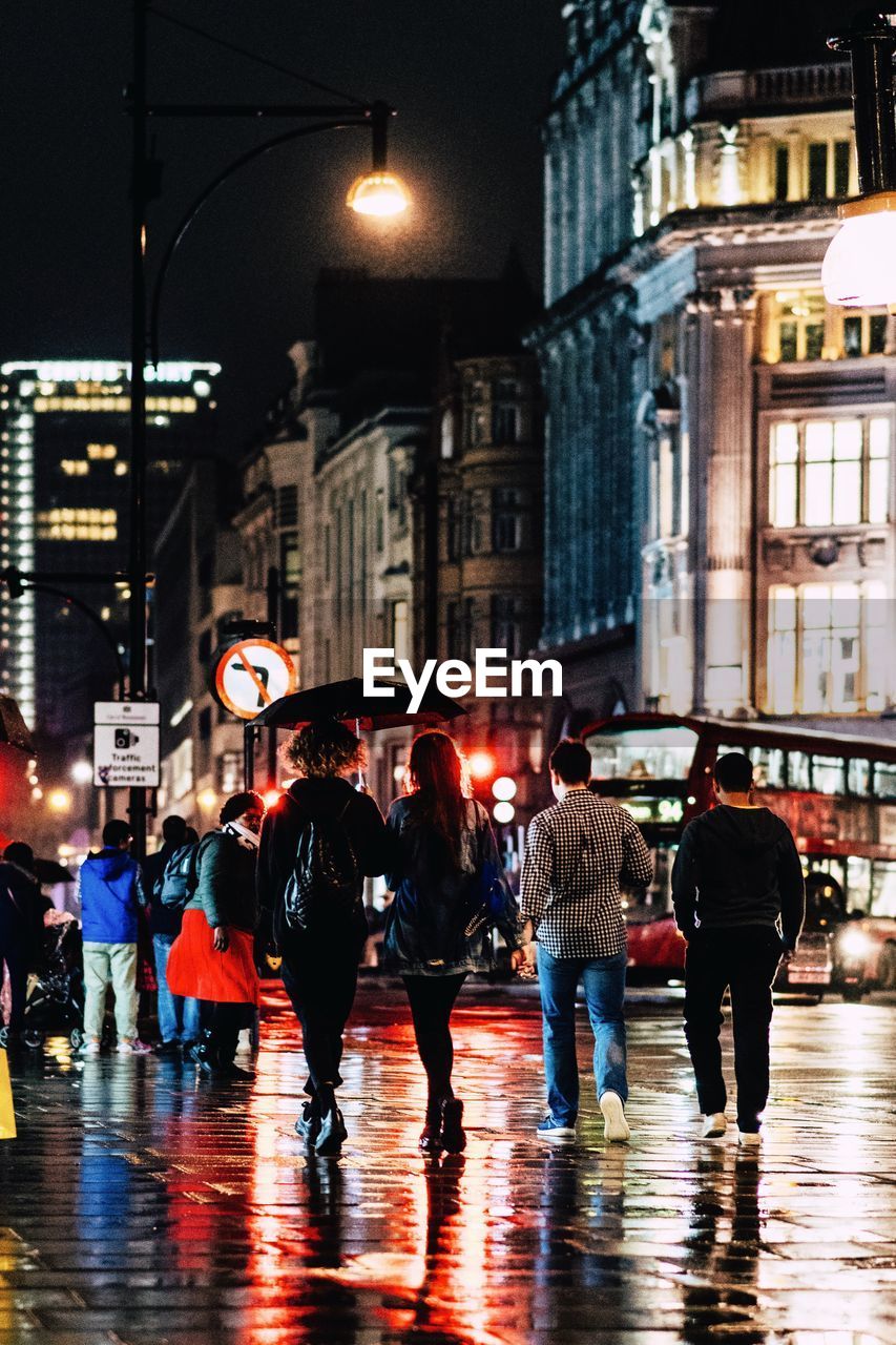 People walking on wet street during rainy season