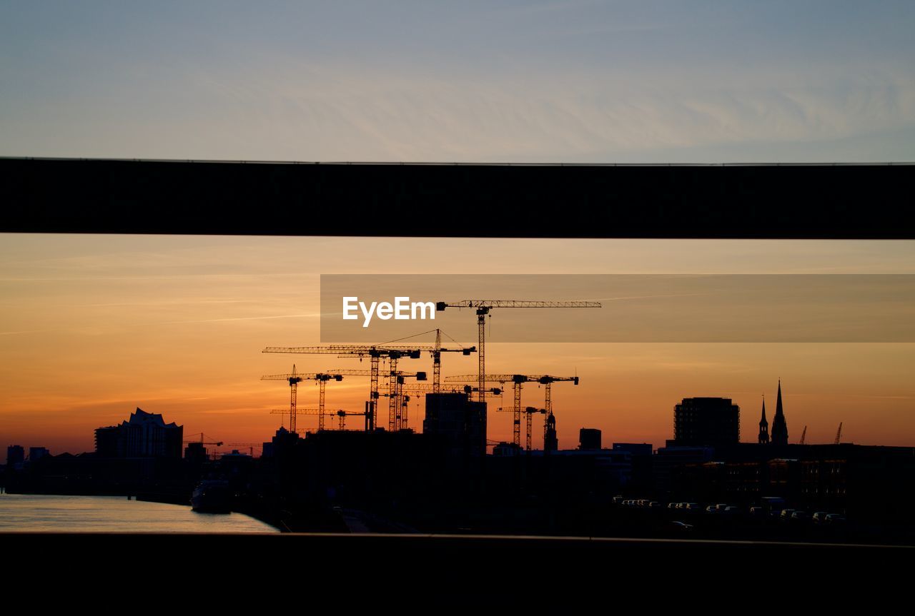 SILHOUETTE BUILDINGS AGAINST SKY AT SUNSET