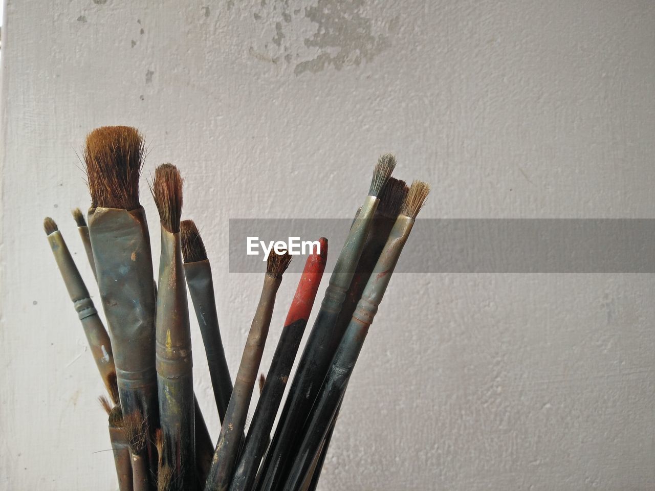 Close-up of paintbrushes against wall
