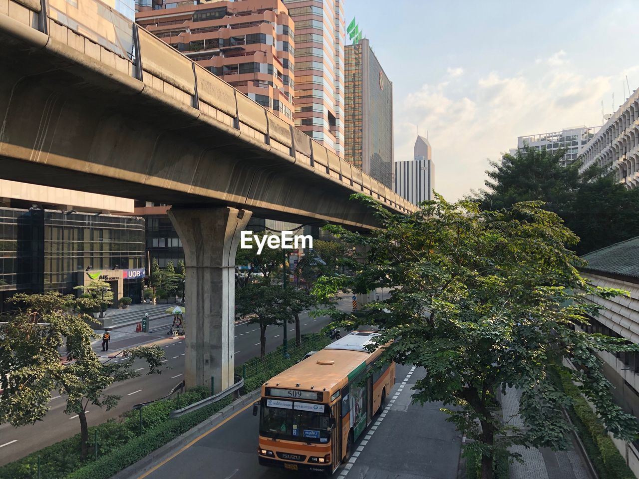 CARS ON ROAD AMIDST BUILDINGS AGAINST SKY