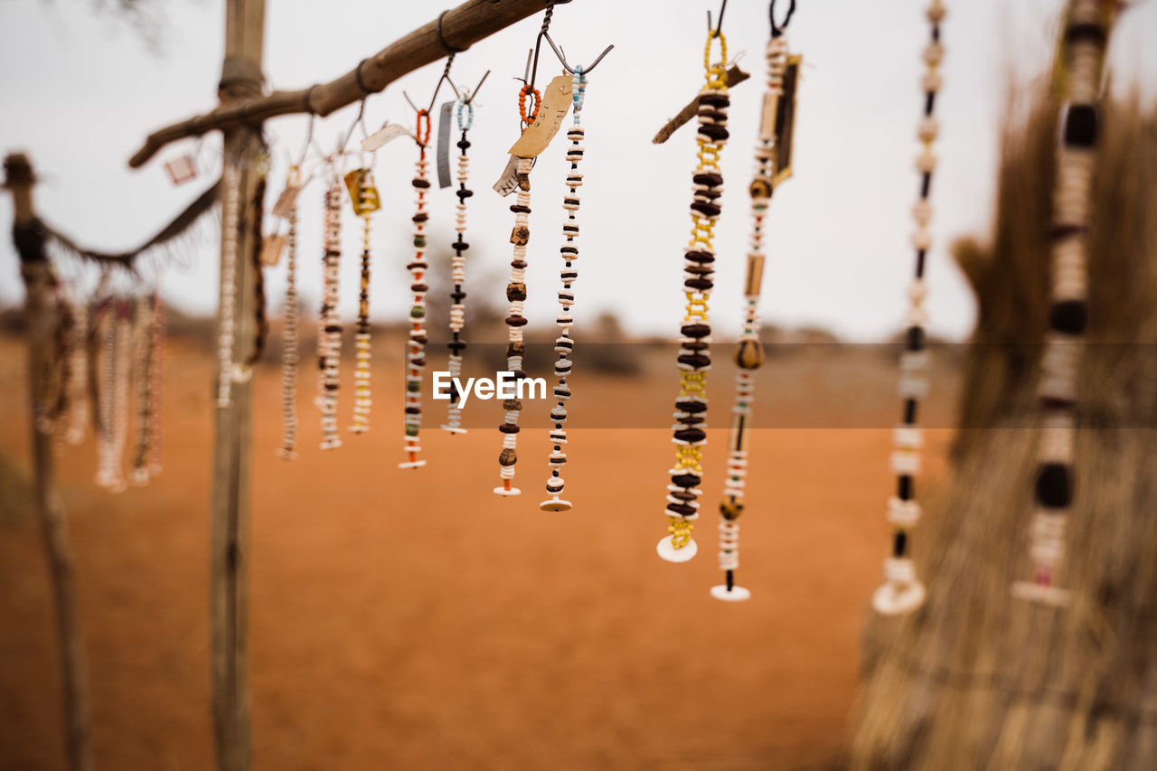 Close-up of jewelries hanging against blurred background