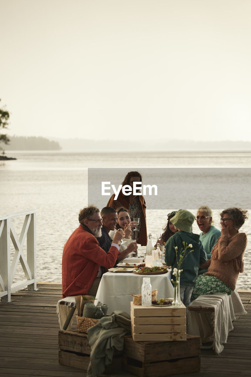 Family having meal at lake