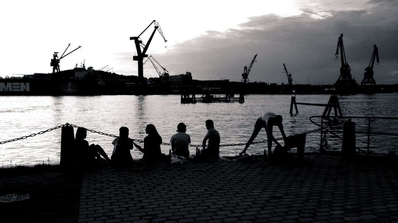 Silhouette people in river bank