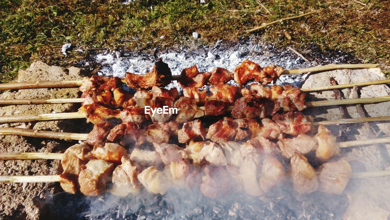 High angle view of meat being roasted over burning coal