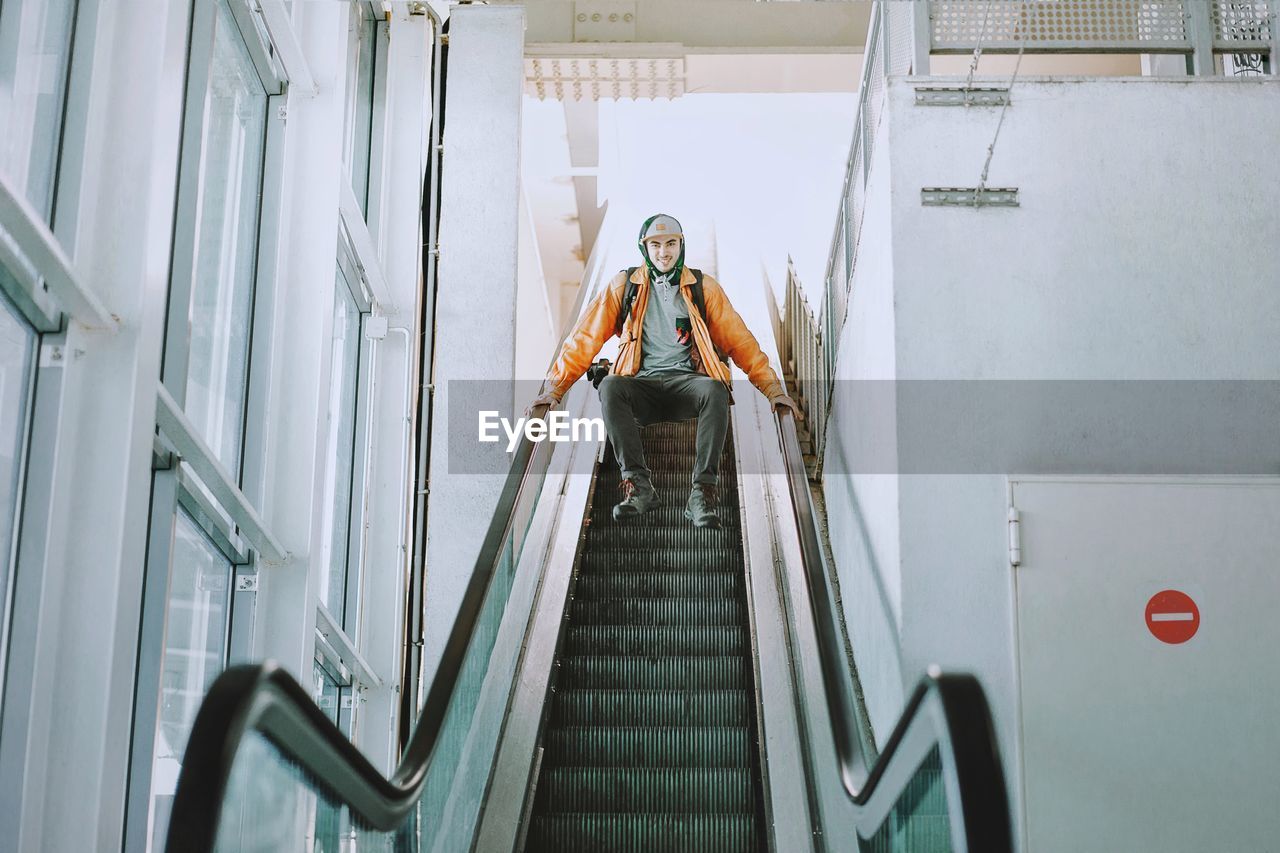 Low angle view of man humping over escalator