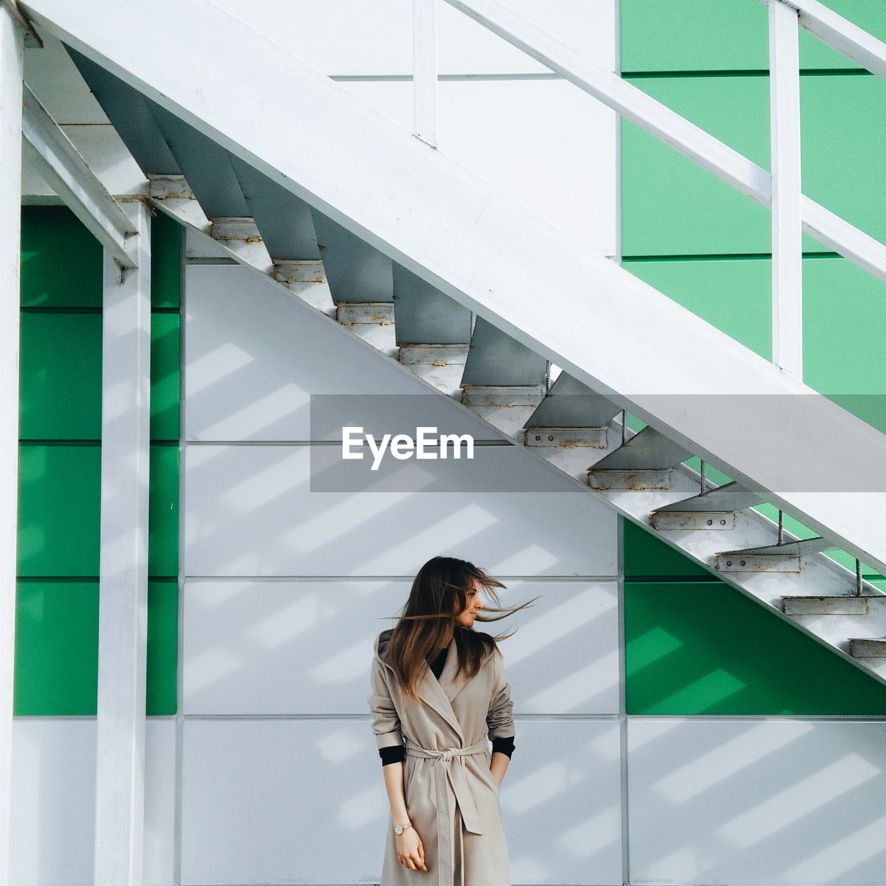 Front view of young woman against modern building