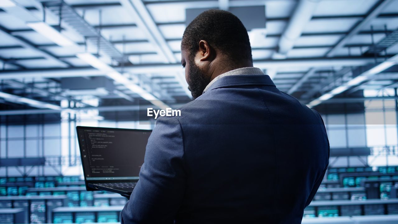 side view of young man looking away against modern office