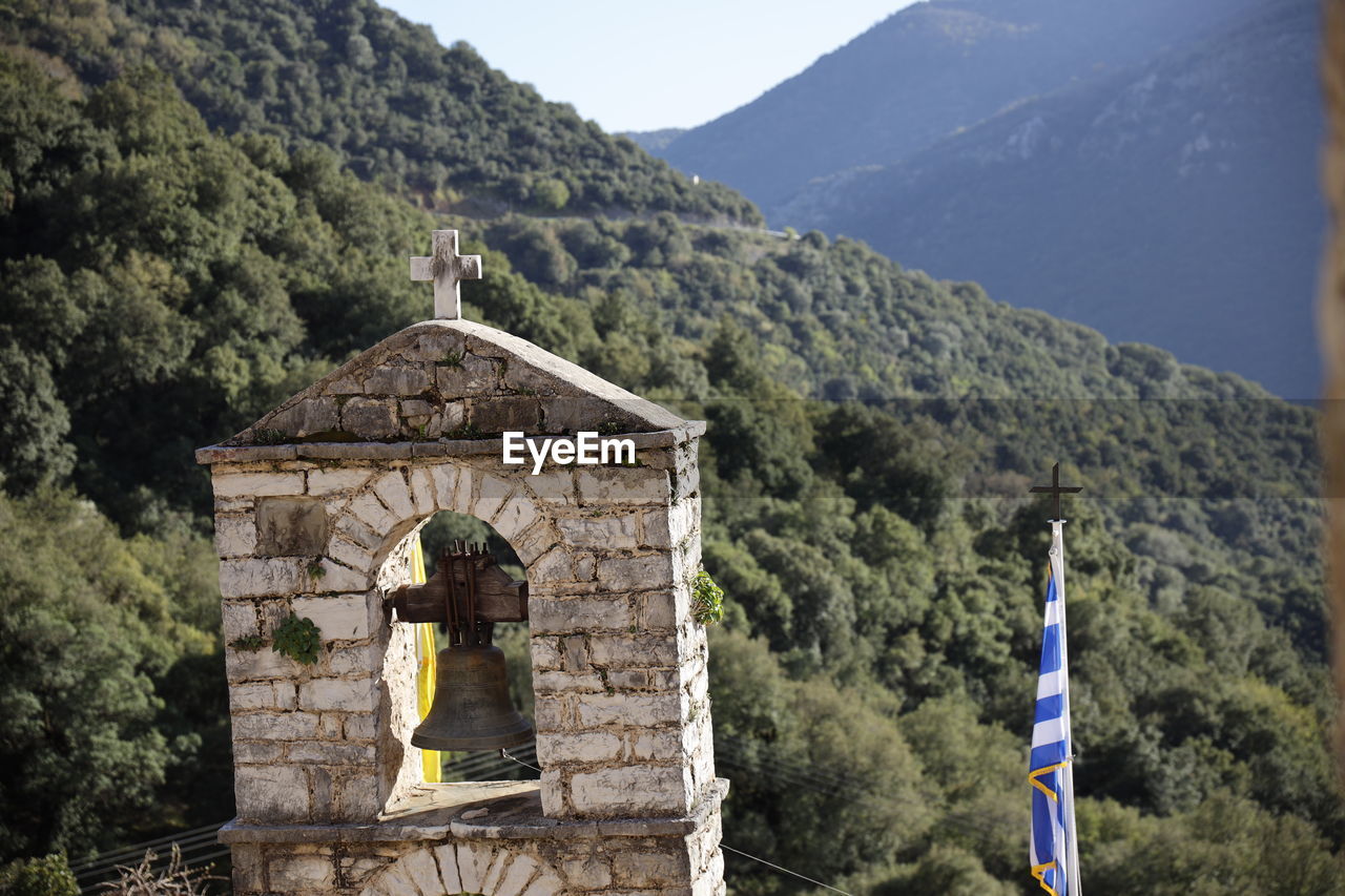 View of bell tower and mountain against sky