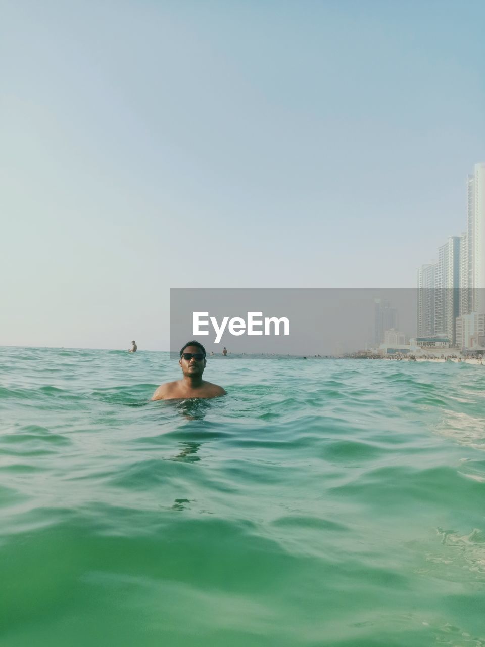 Portrait of man swimming in sea against clear sky