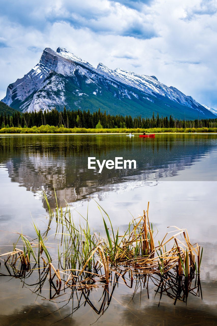 Scenic view of lake by snowcapped mountains against sky