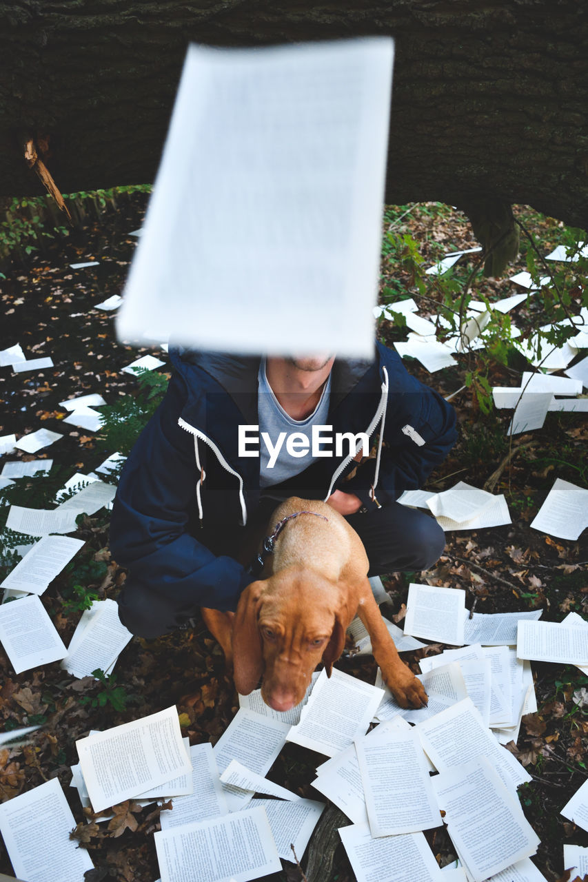 Man and dog with papers on field