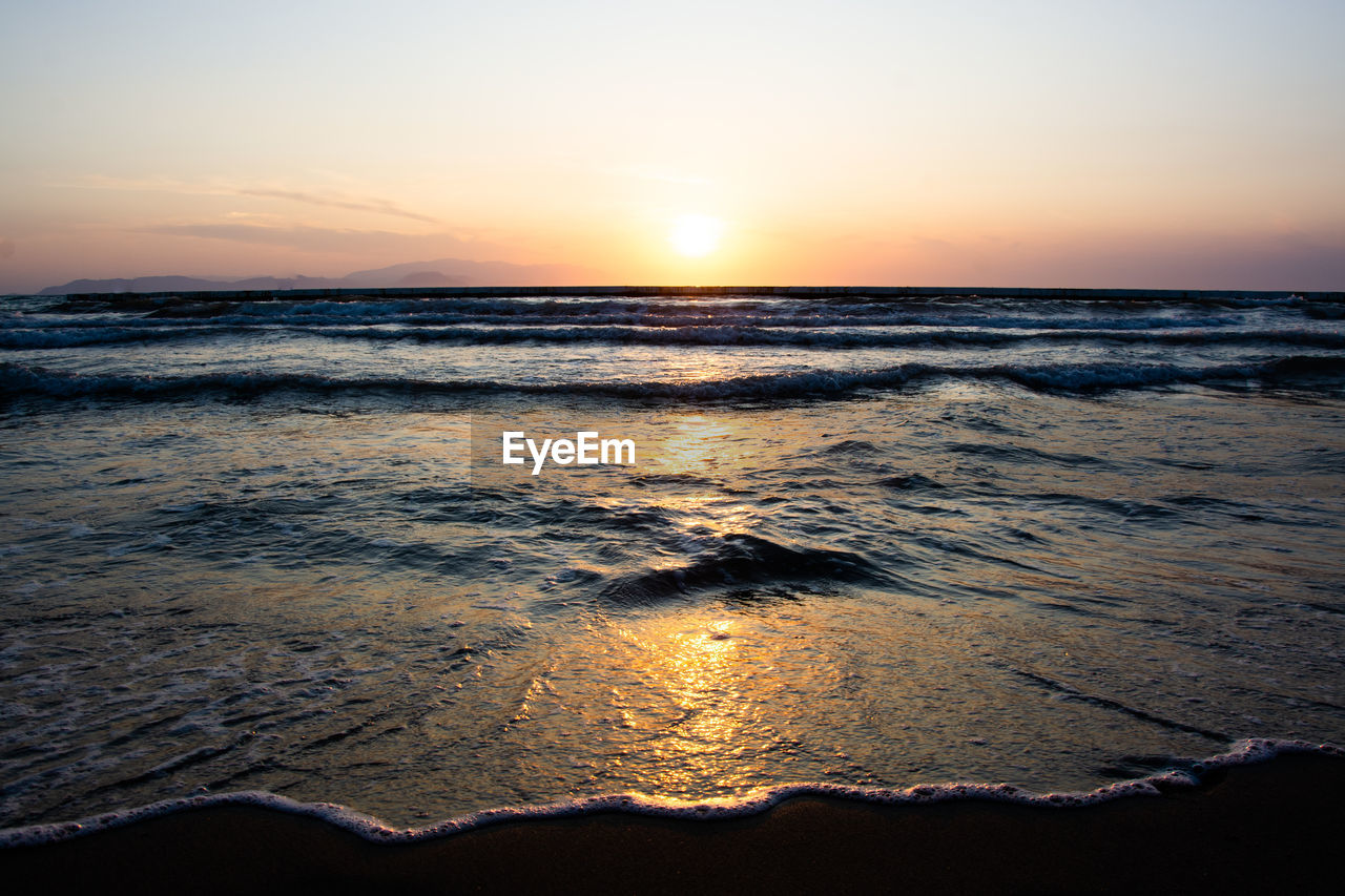 SCENIC VIEW OF BEACH DURING SUNSET